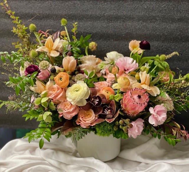 Velvet Fall - Theme Colors: Shades of pink, orange, violet, white and green  Featured Blooms: Roses, Ranunculus, Protea, Lysianthus, Tulips, Lomelosias, Green Craspedias, Orchids, Dianthus and greeneries.  HK Flowers have a uniqueness of florals and seasonal blooms, certain flowers or colors may not be available as each season affects the availability, color, size, and shape of each floral bloom. Some flowers may be substituted accordingly.  Photos are used as a reference for the color palette and is NOT indicated of the final product. We ask for your trust in us that we will pick out the best seasonal available blooms, while still capturing the arrangements theme and colors mentioned above.