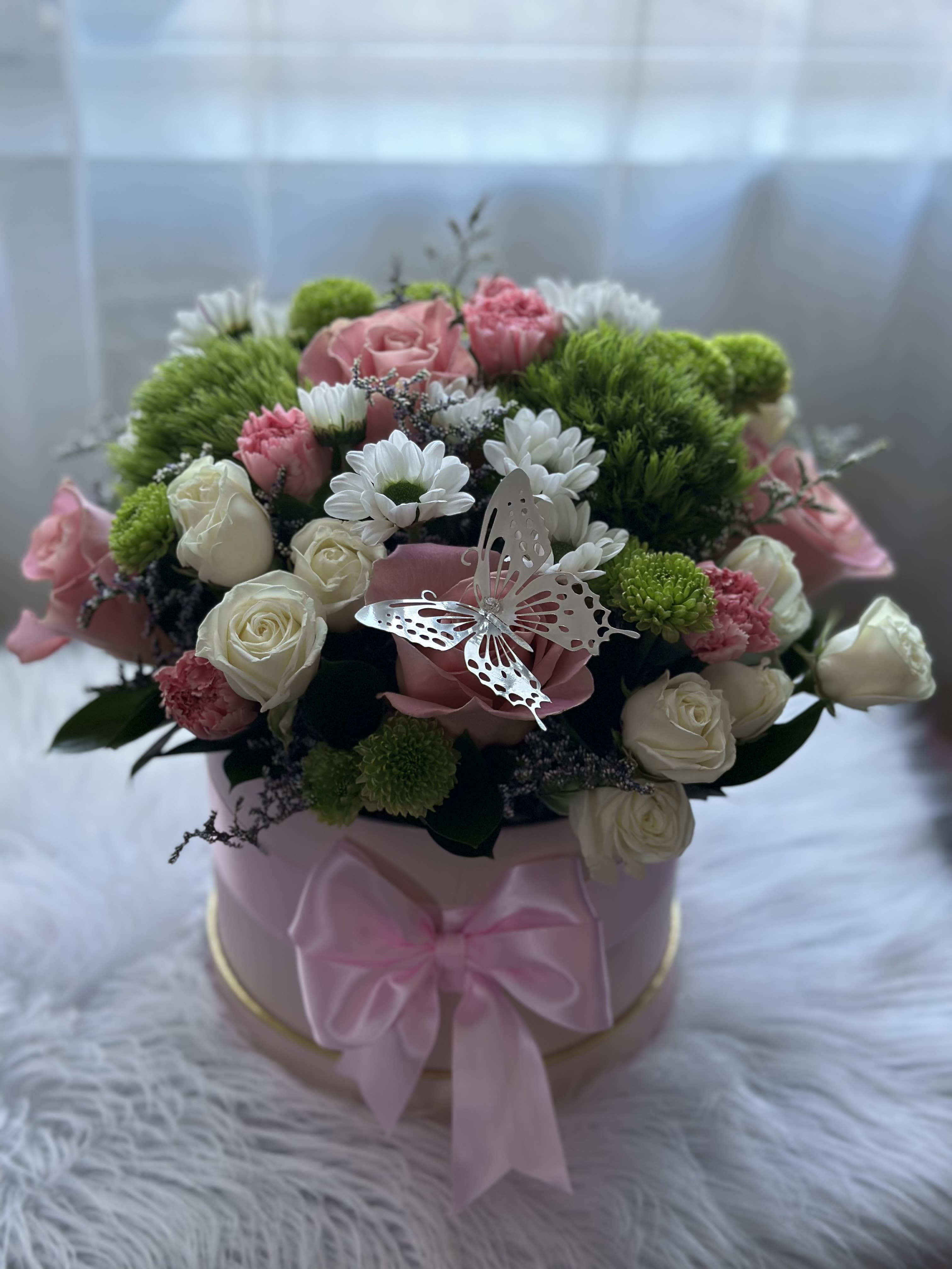 Mixed box arrangement - This beautiful selection of fresh flowers is elegantly arranged in a hat box, featuring roses, carnations, daisies, greens and more (some flowers can be replaced by others of equal value due to their season or availability)