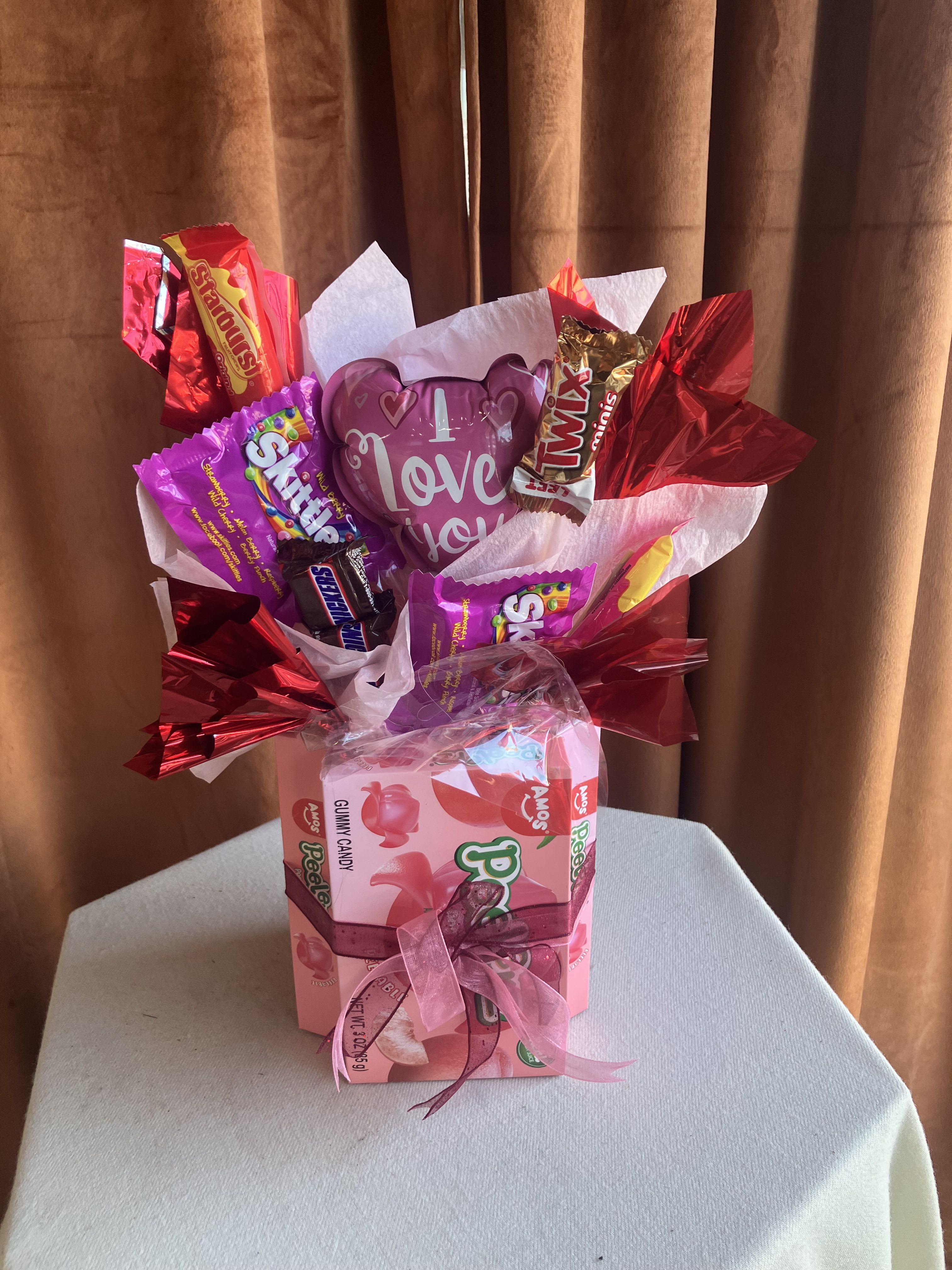 Valentine's Day Candy Bouquet - This festive candy bouquet is a sweet and playful way to share the love. Featuring a cheerful assortment of popular candies arranged bouquet-style and accented with Valentine’s wrapping, ribbon, and a heart detail, it’s designed to delight at first glance