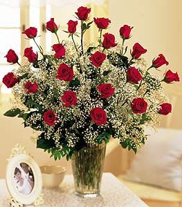 24 Red Roses - Two dozen long stem Freedom roses among a variety of greenery and complimented with a filler flower.  Designed in a clear glass vase.  