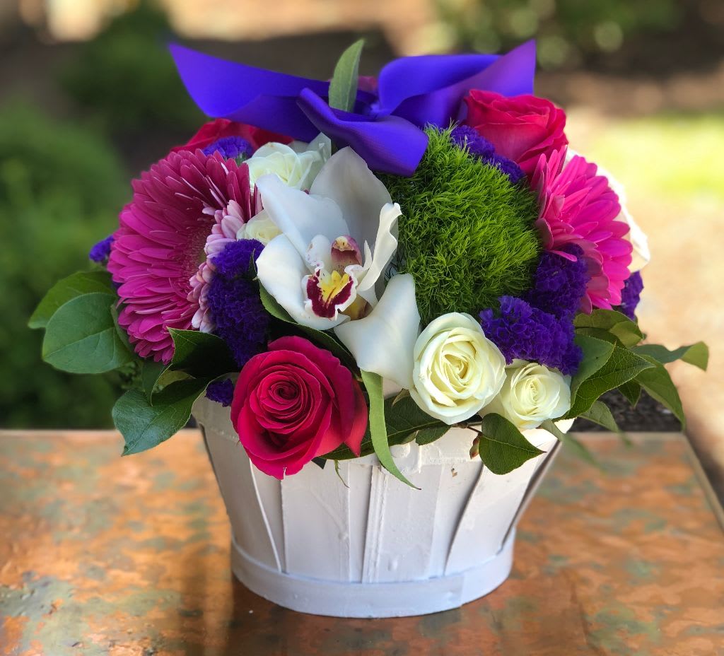 We Love You - We Love You – Vibrant Flower Basket | Wilmington, Delaware Florist Show someone how much you care with We Love You, a bright and cheerful floral arrangement from your trusted local florist in Wilmington, Delaware. This charming design features fresh green dianthus, elegant dark pink and white roses, bold dark pink Gerbera daisies, and delicate purple statice, all beautifully arranged in a charming basket and finished with a purple satin ribbon. Perfect for birthdays, anniversaries, thank-you gifts, or just-because surprises, this arrangement is a heartfelt way to say “We Love You.” Available for tax-free hand delivery in Wilmington, DE and surrounding areas including Newark, Chadds Ford and Kennett Square. Handcrafted with premium, fresh blooms, this arrangement ensures your thoughtful gift arrives vibrant, beautiful, and ready to impress. Order We Love You today and brighten someone’s day with the expert touch of your Wilmington, Delaware florist