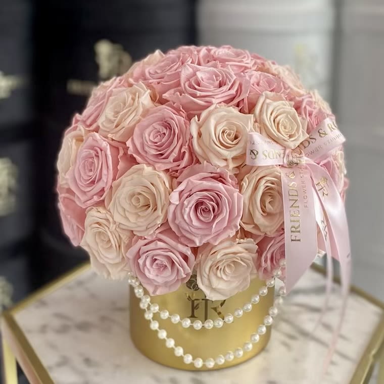 Powder (Preserved Roses) - A breathtaking display of 50 powdery pink eternal roses, delicately arranged in a luxurious gold vase adorned with shimmering pearls. Timeless elegance captured in a piece that speaks of grace, love, and refined beauty.
