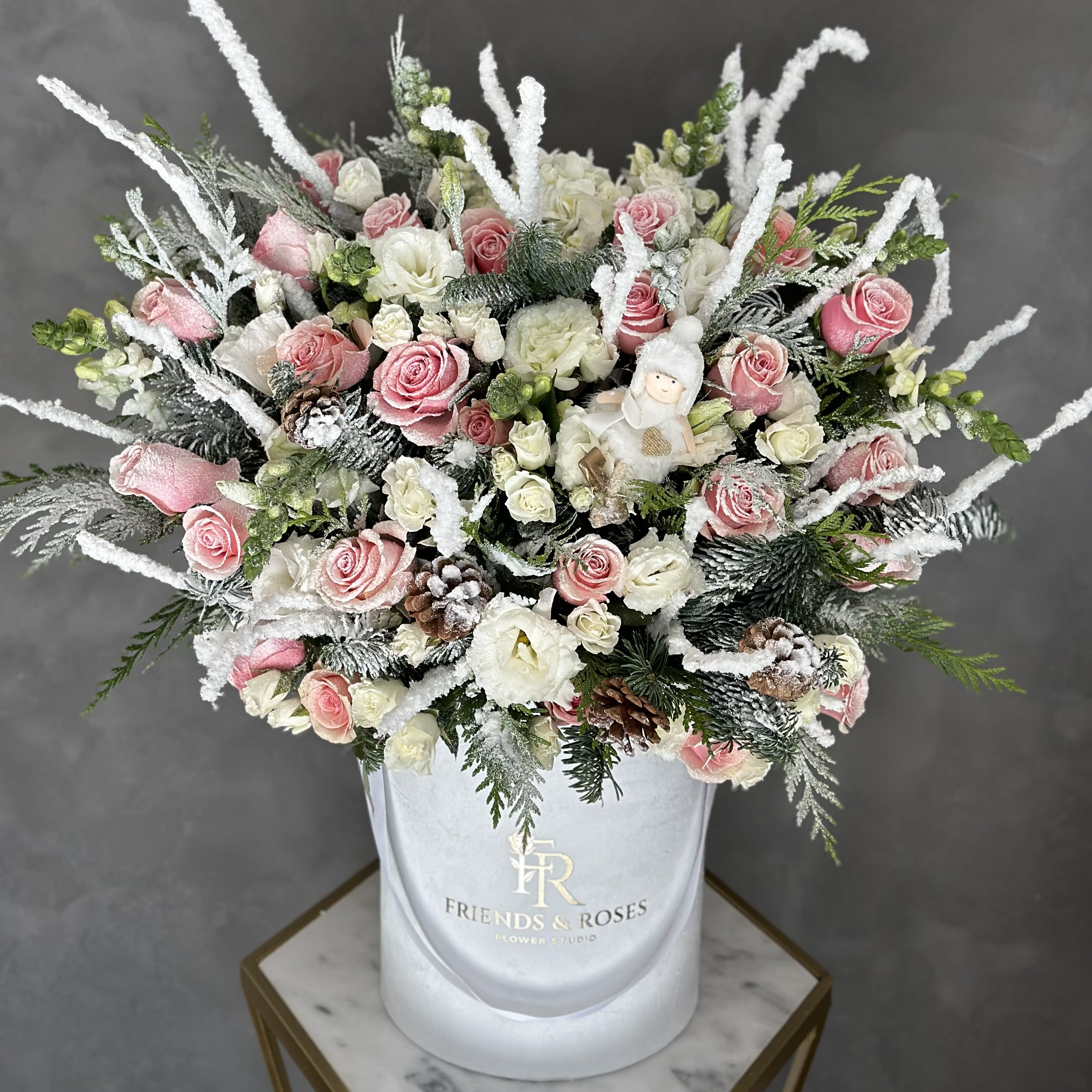 Winter Wonderland  - Our white signature box holds a stunning holiday arrangement with premium flowers, Christmas tree branches, a small angel, and other accessories. Masterwork by our best florist. A truly unique present for your friends and family members or home accent 