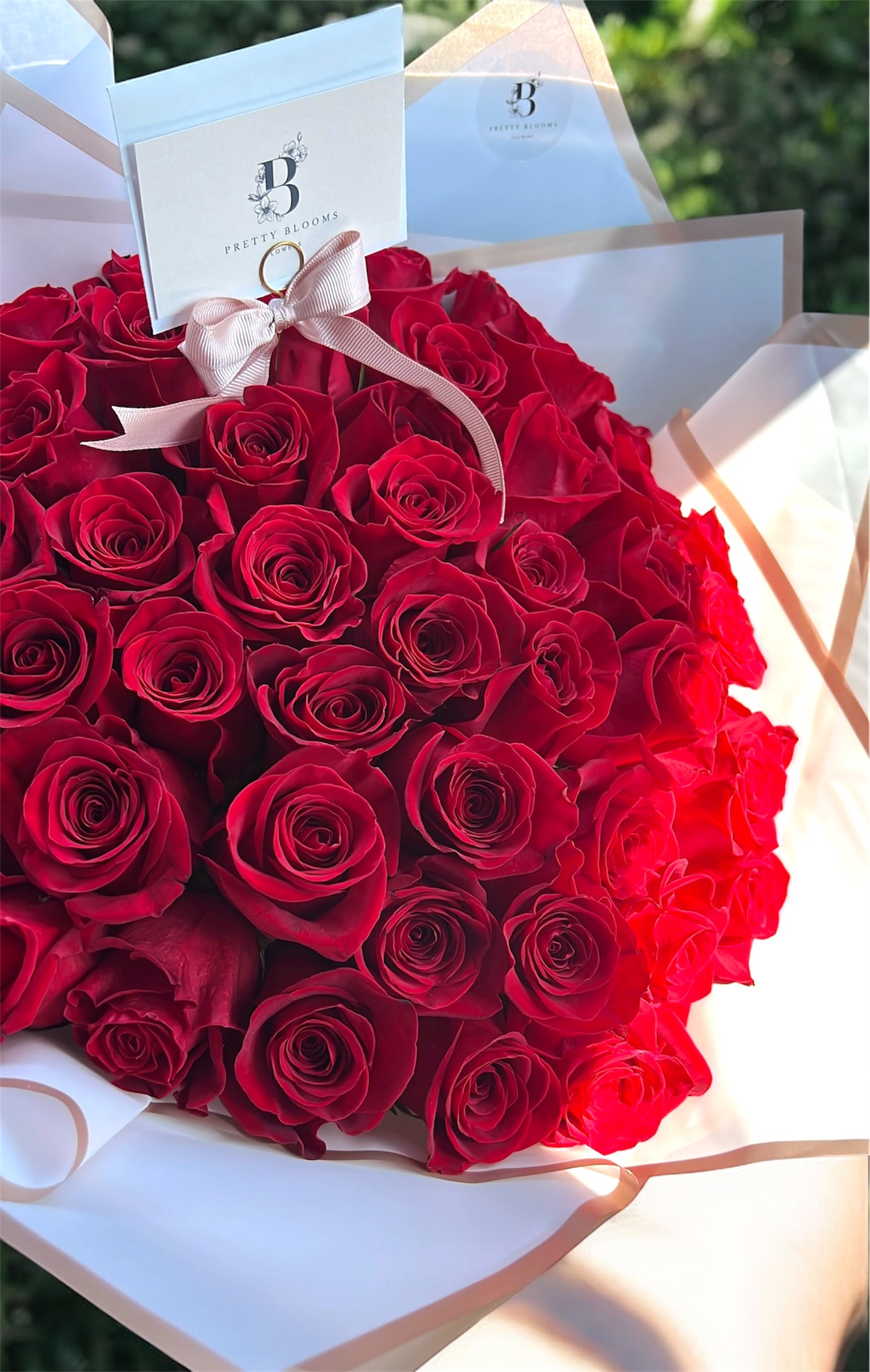 Red Roses Bouquet - A Stunning wrapped bouquet of 50 long stem premium red roses. Perfect for expressing love, romance and affection.  Paper wrapping may vary from picture.