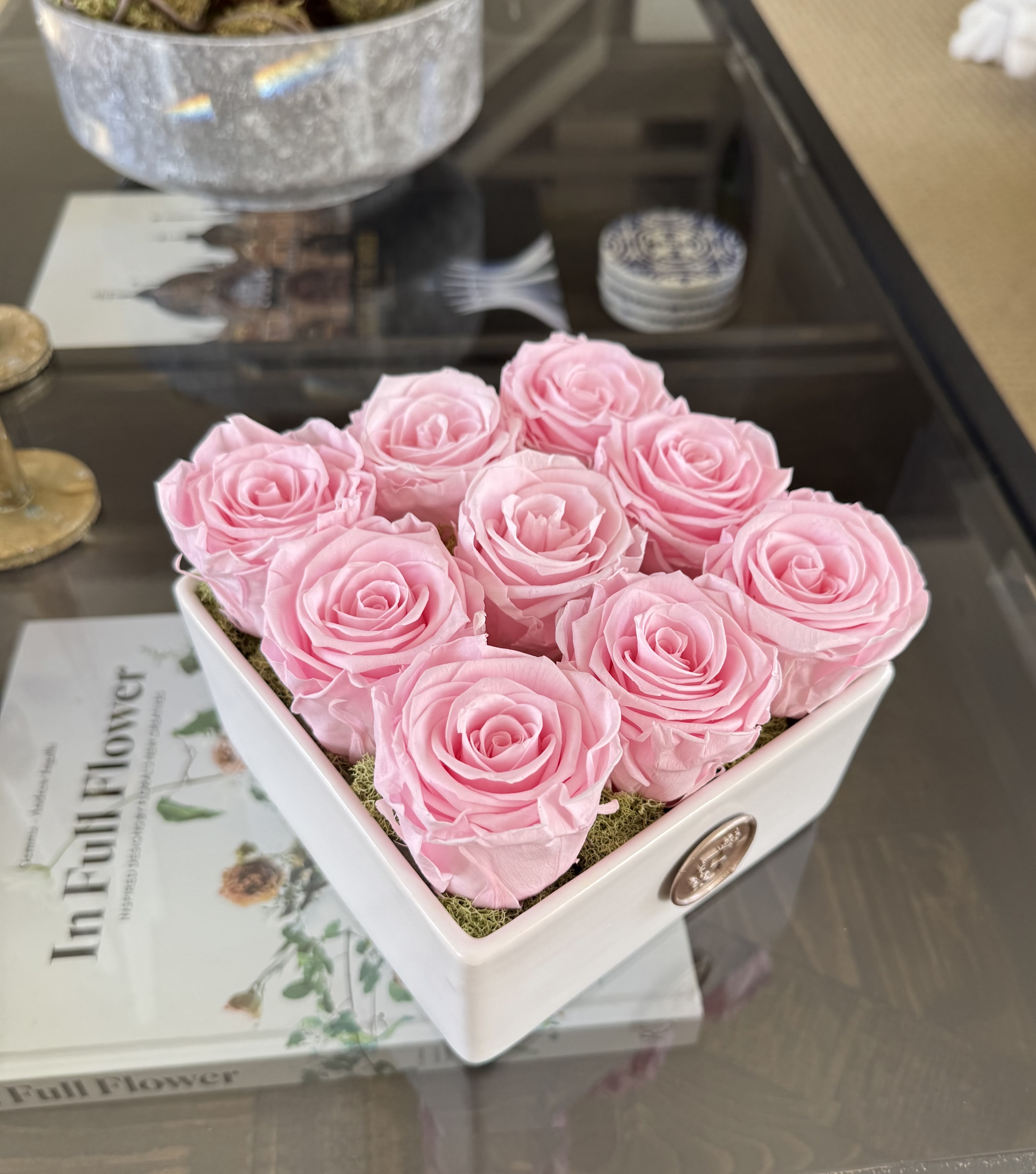Eternal Nine in Pink - This elegant arrangement features nine preserved pink roses, artfully arranged in a sleek white square ceramic vase. With its minimalist design and modern appeal, it’s the perfect accent for coffee tables, desks, or shelves.  Ideal for birthdays, anniversaries, or romantic gestures, these premium roses are specially treated to retain their beauty and fresh appearance for 12 months or longer. No water or maintenance required.