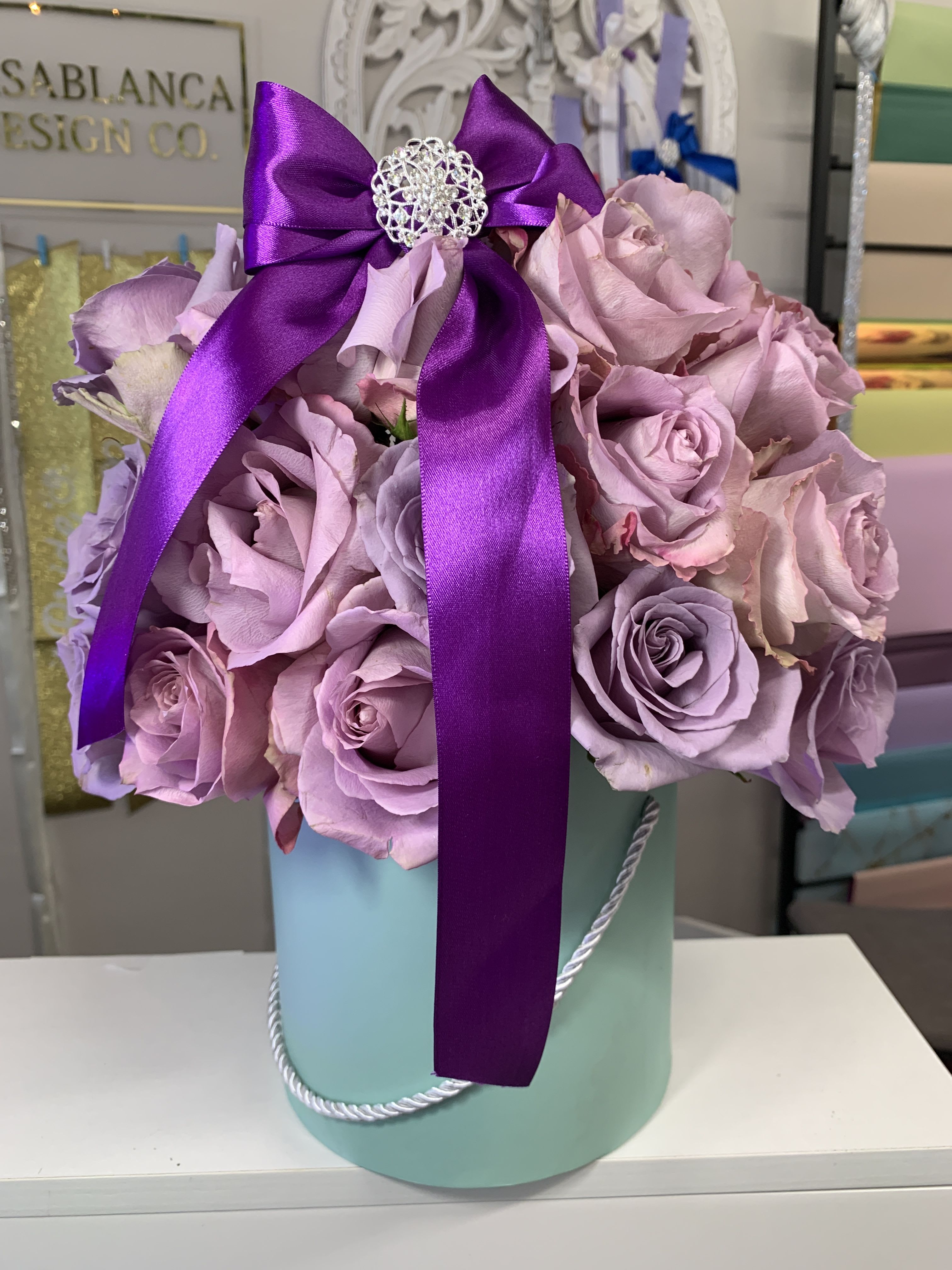 Jasmine  - Lavender roses in a light teal box with a purple bow 