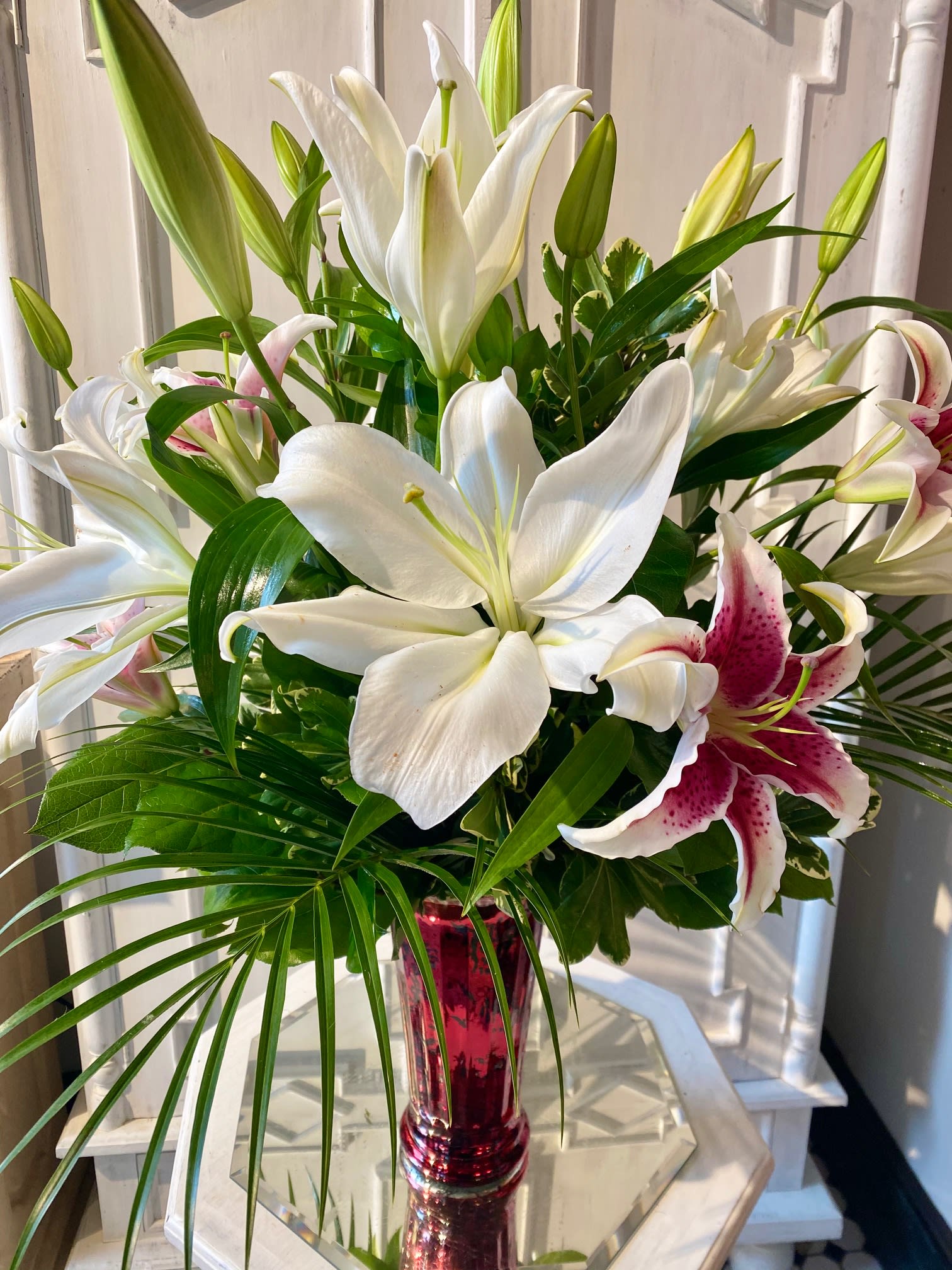 Lily Love - Beautiful and fragrant, "Lily Love" is an array of beautiful orient Lilies in Pink and White. Designed in a tall glass vase with tropical foliages