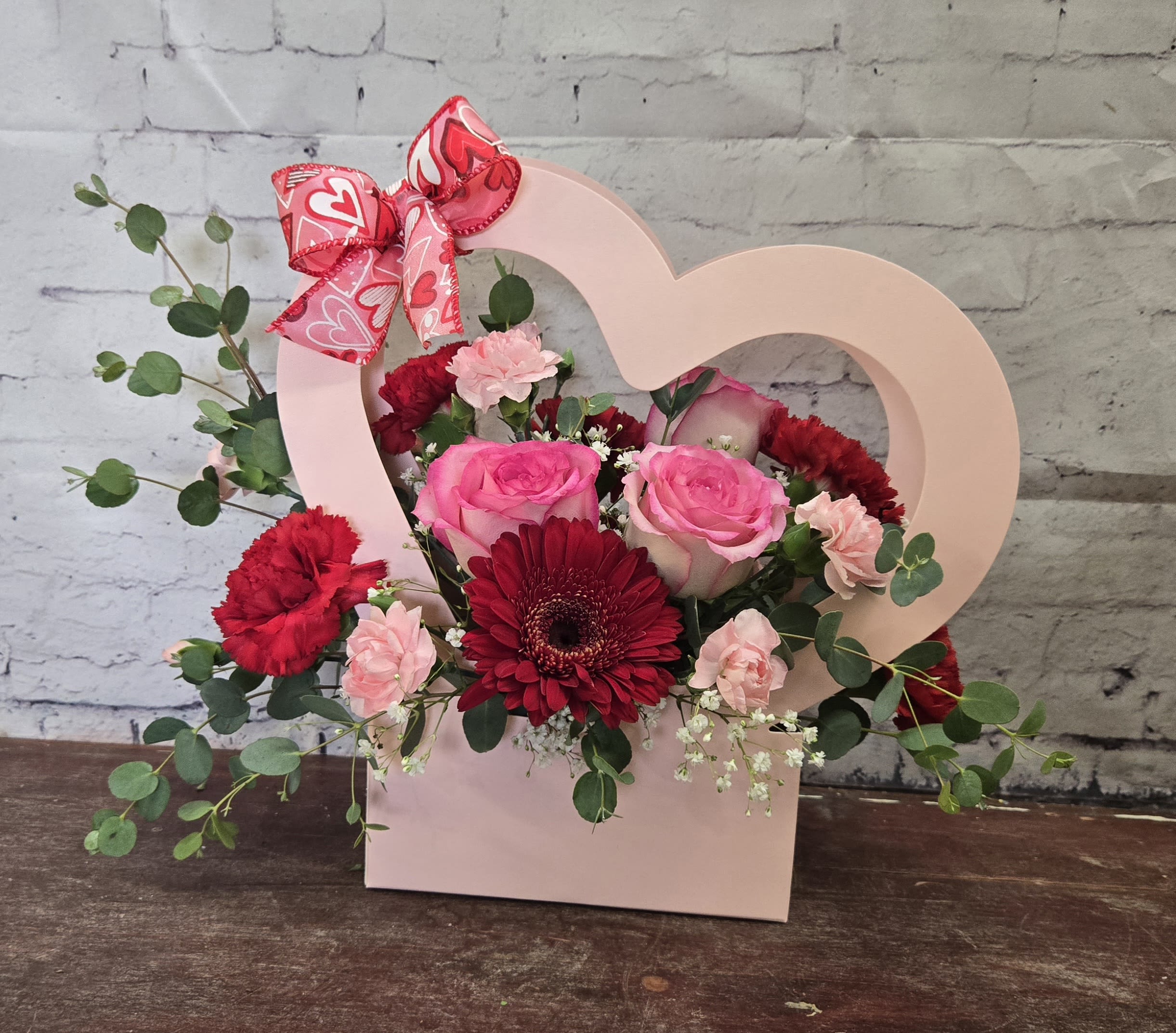Heart Strings - Pink heart container with pink and red flowers.