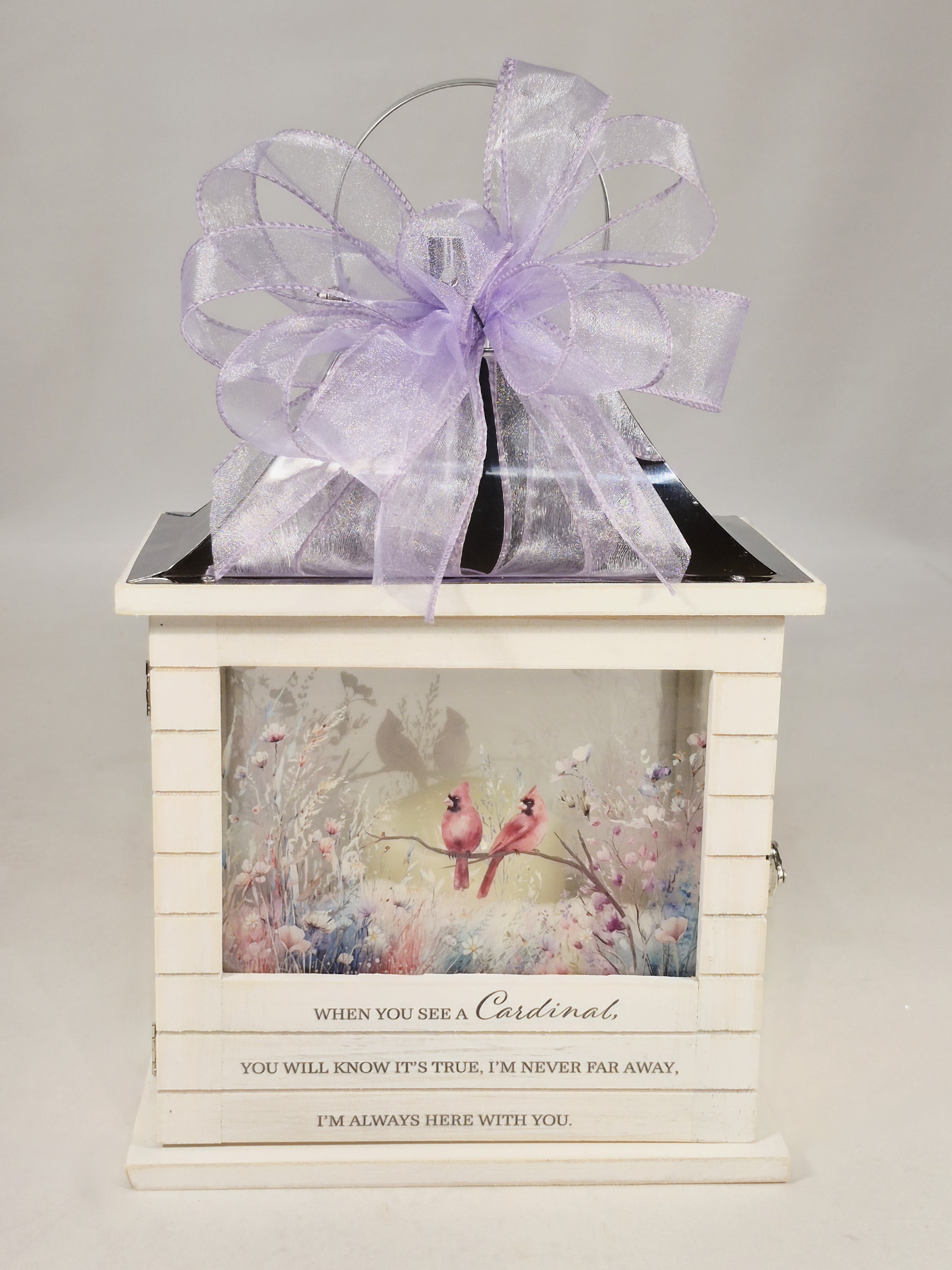 Cardinal Wooden Lighted Lantern - Our Wooden Slat lanterns are made with quality wood with a stainless steel finish top. They come inscribed with sentimental quotes amid beautiful artwork on all four sides and a charming flameless LED candle. Suitable for hanging or use as a freestanding item. They are weather friendly!  3 AAA batteries are included. Comes with a matching bow.   Lantern Reads: "When you see a Cardinal, You will know it's true, I'm never far away, I'm always here with you."  W: 8.75" H: 12.5" D: 5.25"