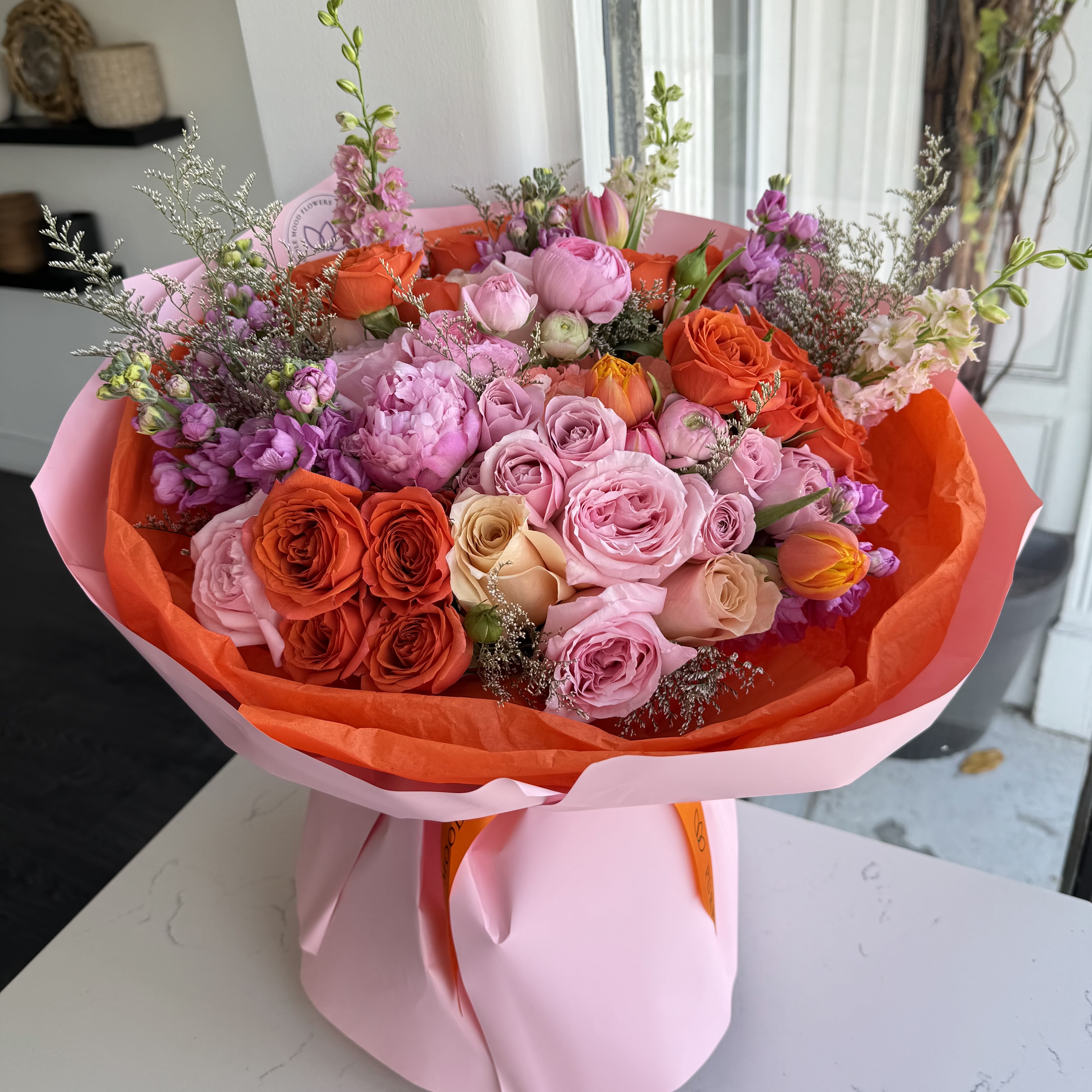 Coral Crush Bouquet  - A bold and vibrant bouquet designed to make a lasting impression. Featuring a stunning mix of coral, blush pink, peach, and lavender blooms—this arrangement bursts with color and texture. Wrapped in soft pink and orange tones, Coral Crush is perfect for birthdays, celebrations, or simply bringing joy to someone special.  Each bouquet is handcrafted with fresh seasonal flowers to ensure a unique and luxurious touch.  VASE NOT INCLUDED