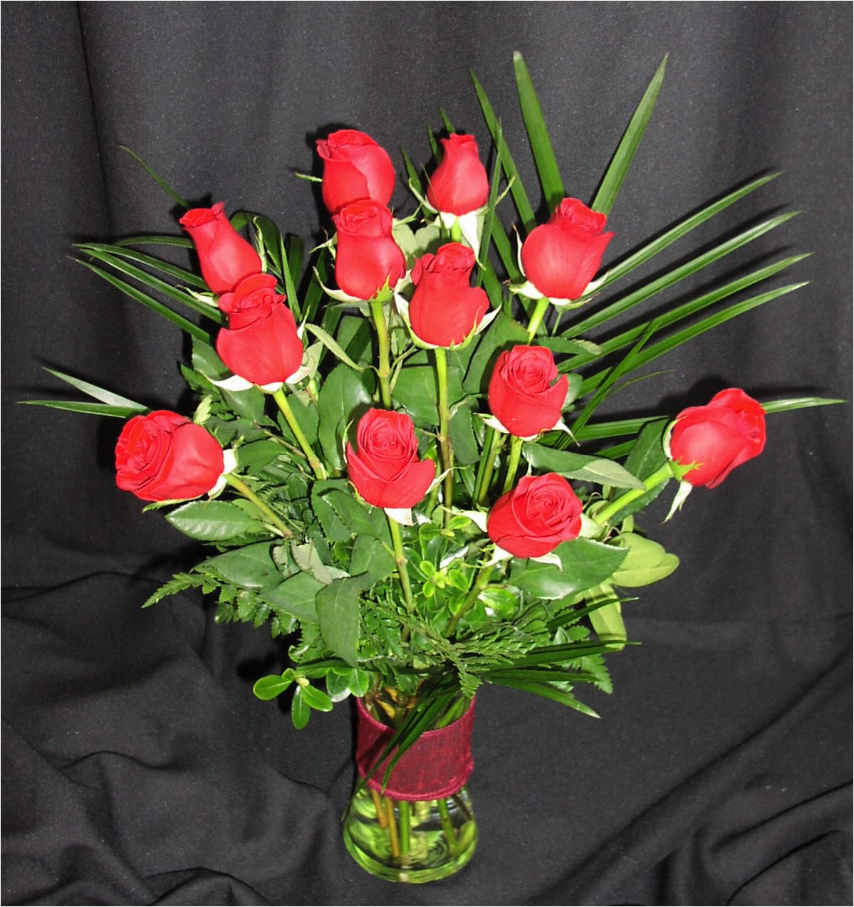 Dozen Understated Red Roses - When less is more, order these elegant premium medium length roses and nothing else. Red will be substituted with a color if unavailable, especially due to shorter than 1 week's notice on the order / 3 weeks prior to Valentine's day. We will email you if a substitution is needed.  Please reply quickly. In some cases if we do  not hear back, we will cancel the order.  Our roses are arranged in a nice vase with a ribbon clutch or bow and gorgeous fresh premium foliage.  Foliage and vase type may vary.  The red roses we carry are Colombian roses and Ecuadorian roses, which are much bigger than red California roses.
