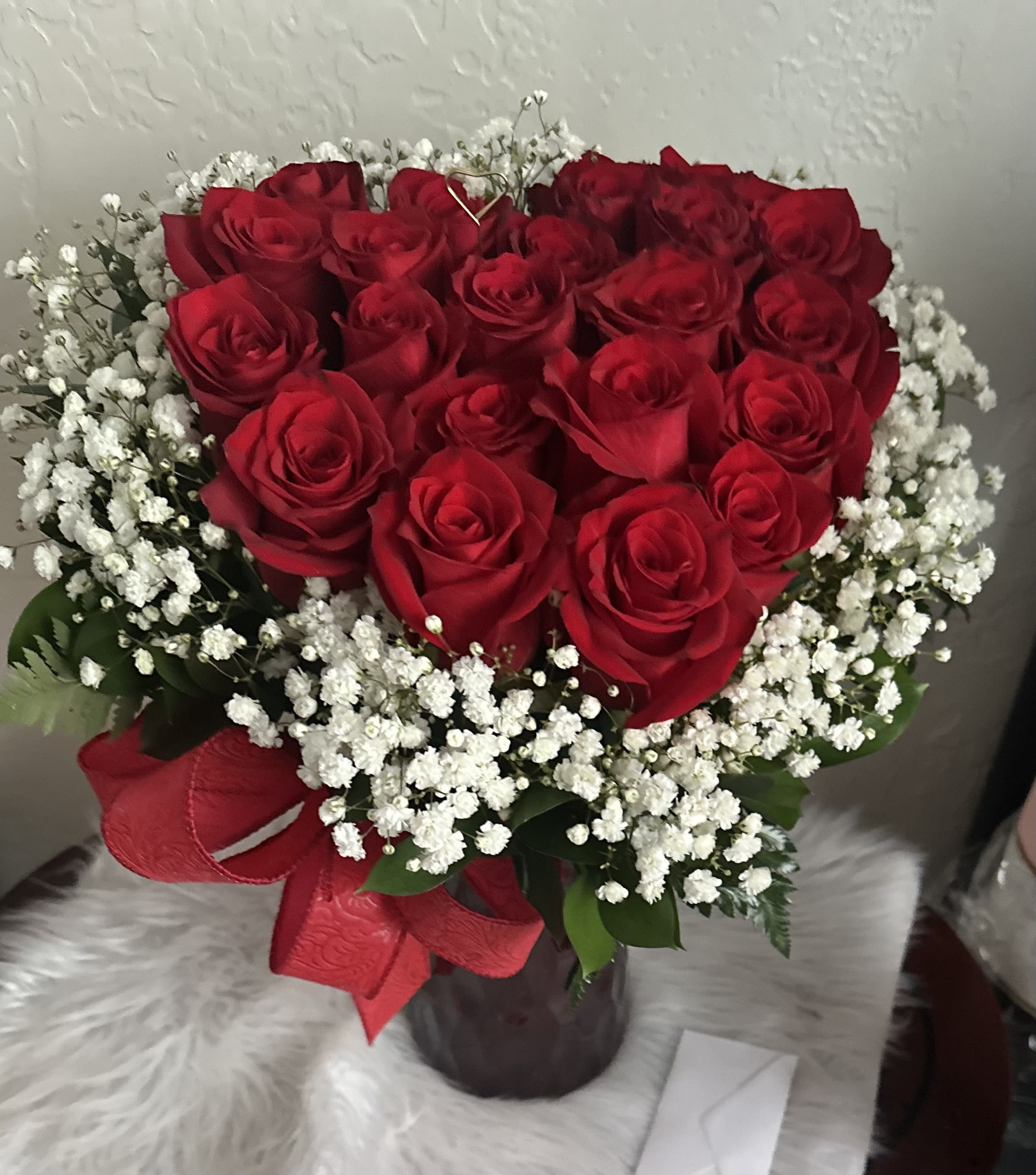 Heart for you - Red roses and white gypsophila in a red glass vase with a satin ribbon.
