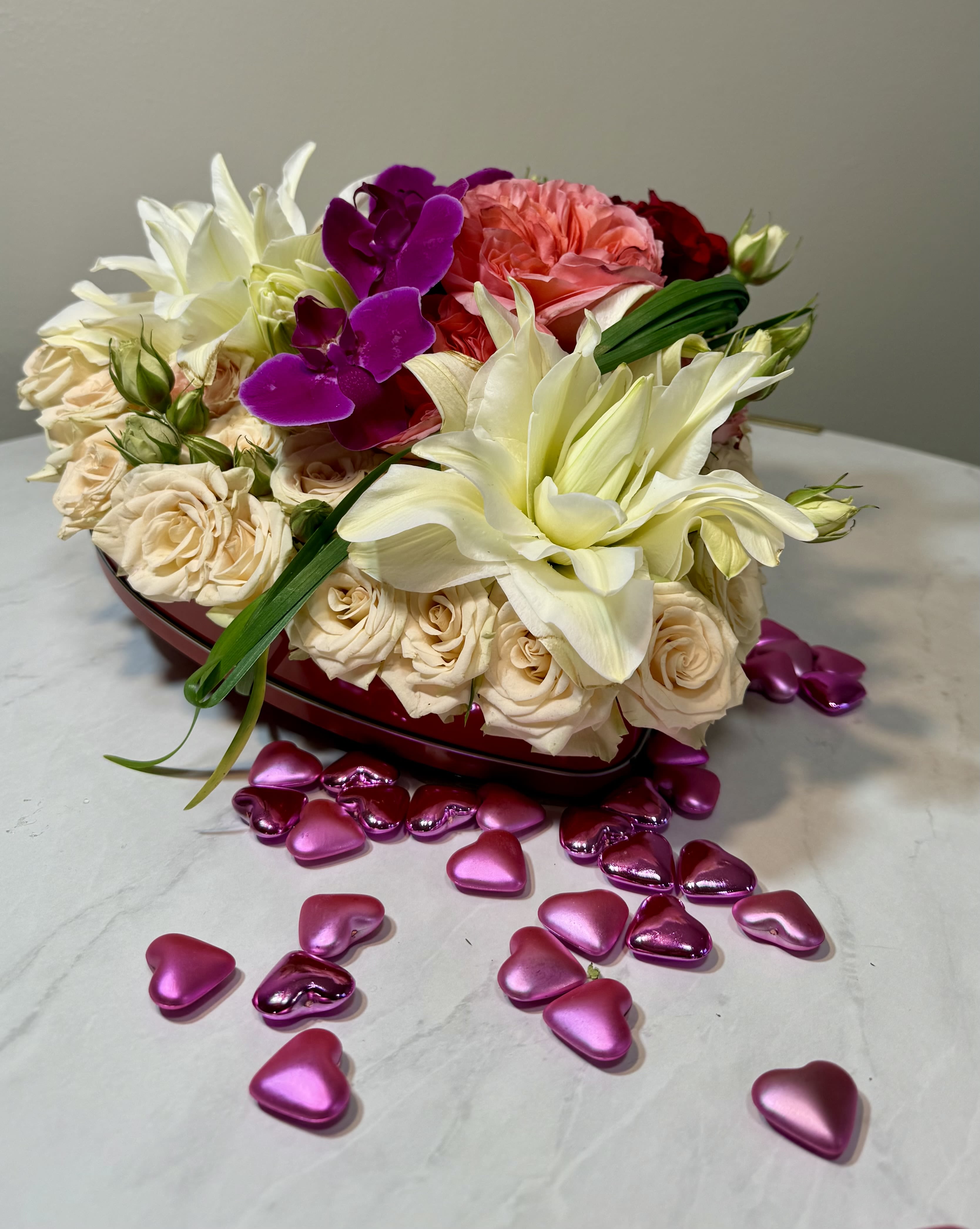 Valentina 1 - Valentine tin heart filled with roses, blush rose lilies and other spring flowers. 6 x 6 in  