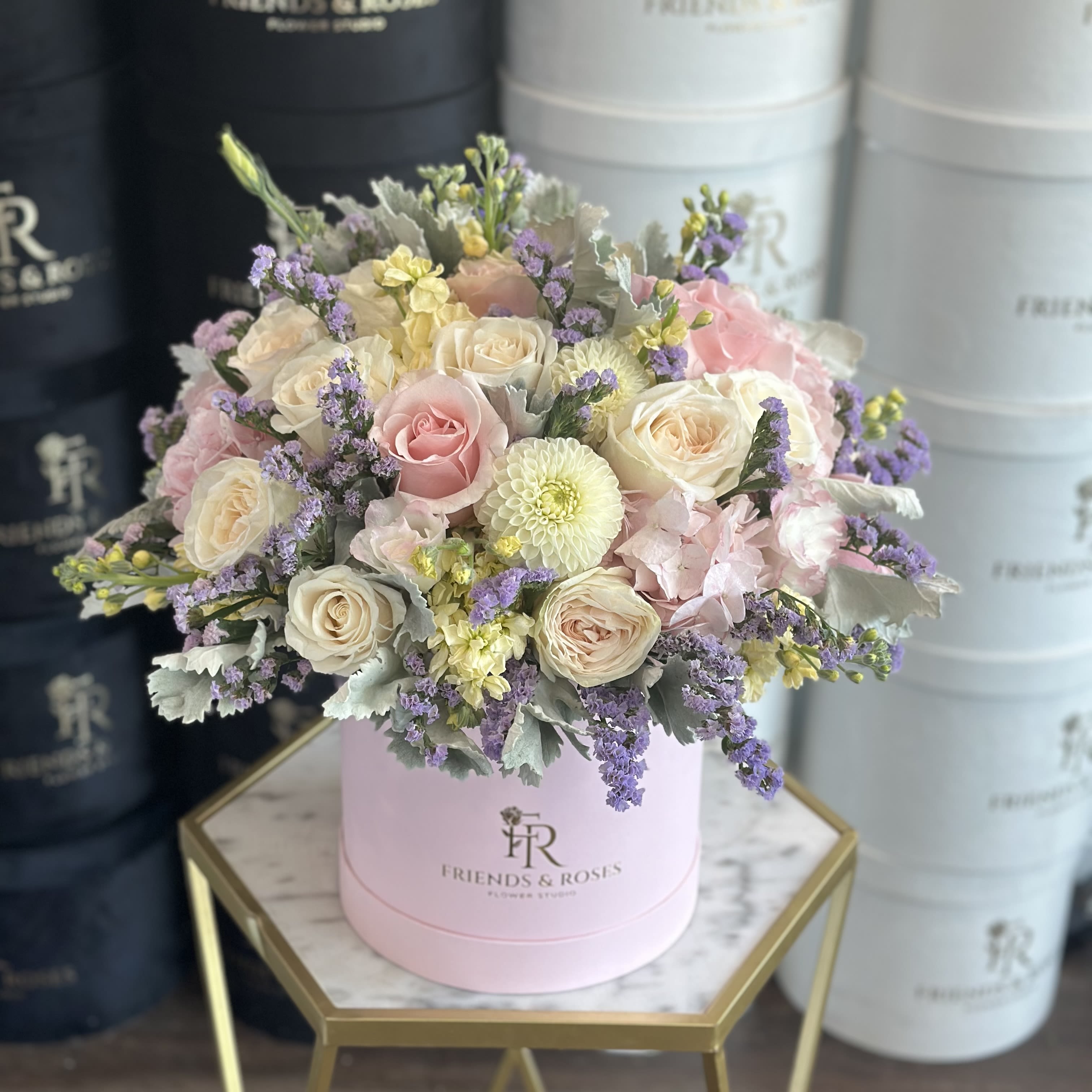 Emmy - A delicate signature flower box featuring a soft assortment of pink, white, lilac, and gentle yellow blooms - elegant and romantic.