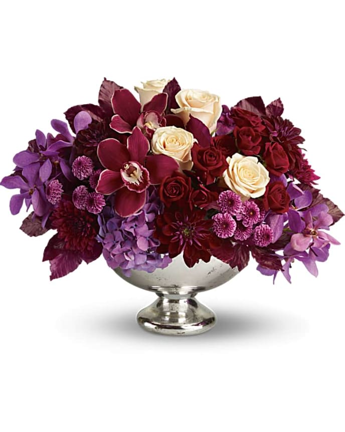 Teleflora's Lush and Lovely - It's elegant, chic, even stunning. But your guests will simply describe it as "Wow!" This luxuriously lush, incredibly stylish arrangement gathers orchids, roses, hydrangea, dahlias and cushion mums into a gorgeous Mercury Glass Bowl. It's sure to make quite an impression as a fall or winter wedding centerpiece - or as a lavish gift delivered to someone truly special. Lush blooms including lavender hydrangea, red cymbidium orchids, purple mokara orchids, crème roses, dark red roses, burgundy dahlias, lavender button mums and purple cushion mums are accented with burgundy copper beech leaves in Teleflora's generous Mercury Glass Bowl. Orientation: All-Around