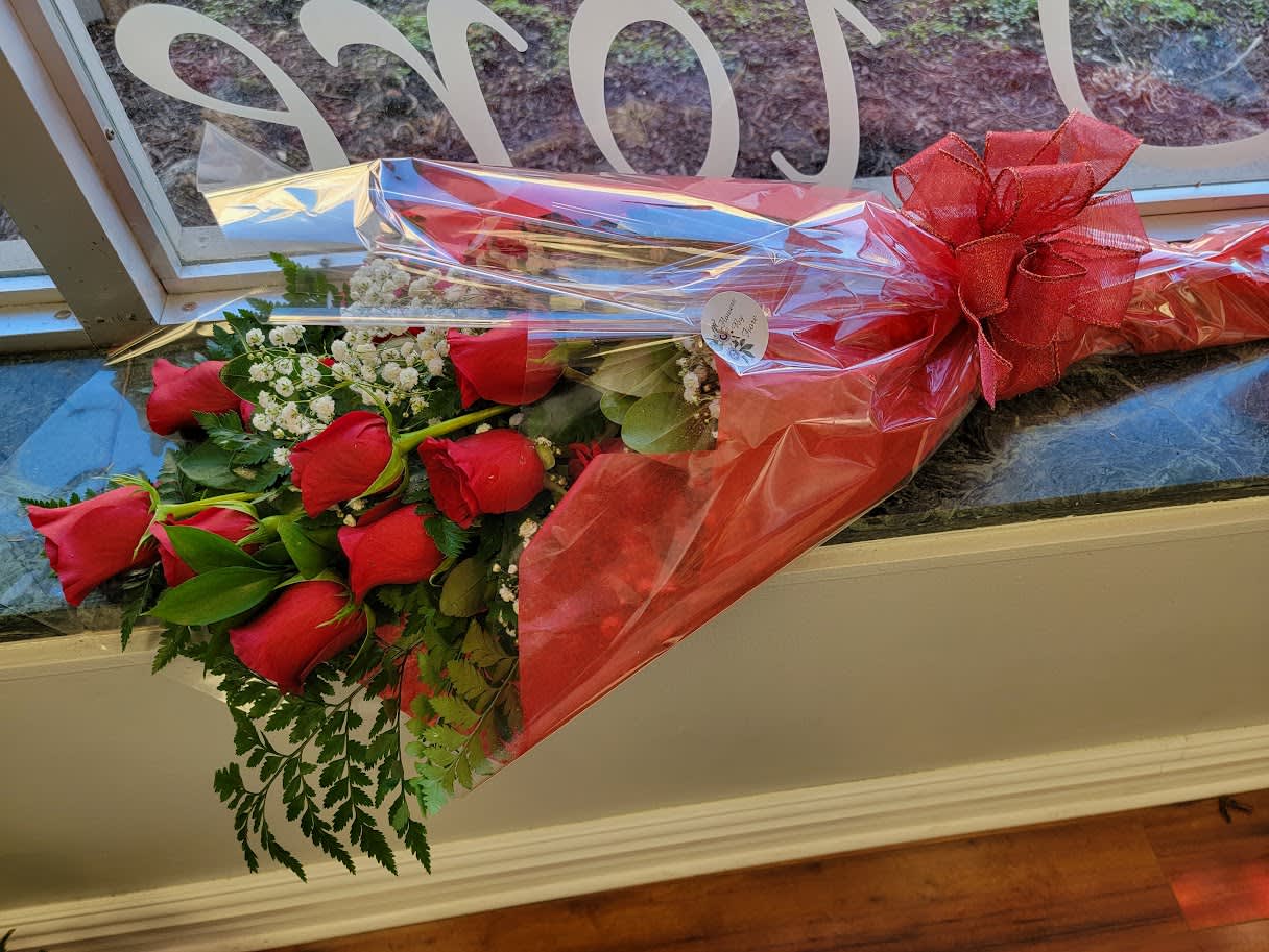 Long stem Dozen Red Rose Presentation Bouquet - REQUEST OTHER COLORS IN SPECIAL INSTRUCTIONS. Twelve true long stem red roses arranged with assorted greenery and filler flower. Make a statement with this grand beauty queen bouquet. Tastelfully wrapped and accented with a matching florist designed bow.  STANDARD is 12 roses, DELUXE Is 18 roses and PREMIUM is 24 roses.  Specific colors can be requested in special instructions.