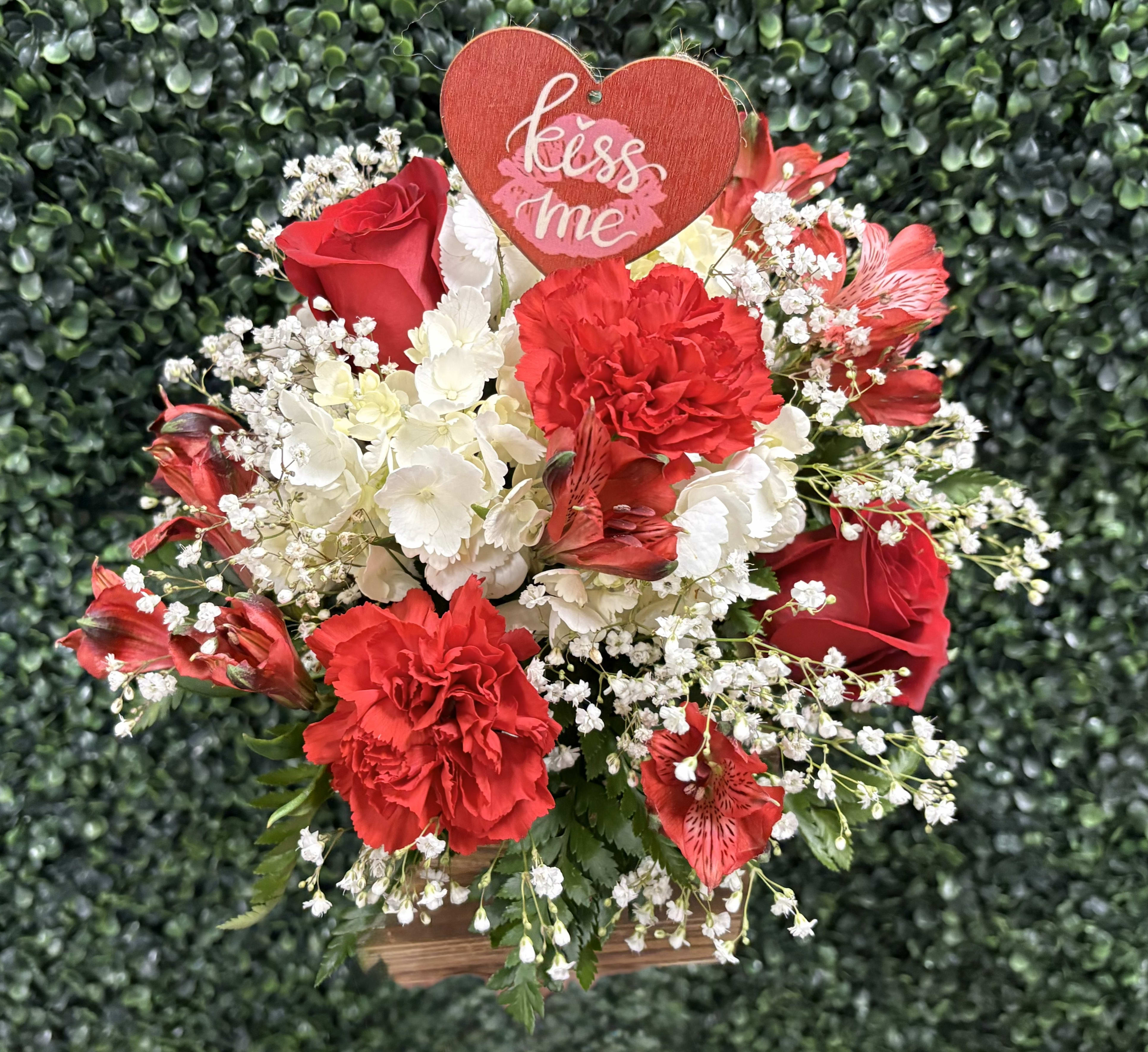 KISS ME BASKET BY BINLEYS - THIS QUAINT WOVEN BASKET IS FILLED WITH MIXED BLOOMS,  ROSES, CARNATIONS, HYDRANGEA, ALSTROMERIS