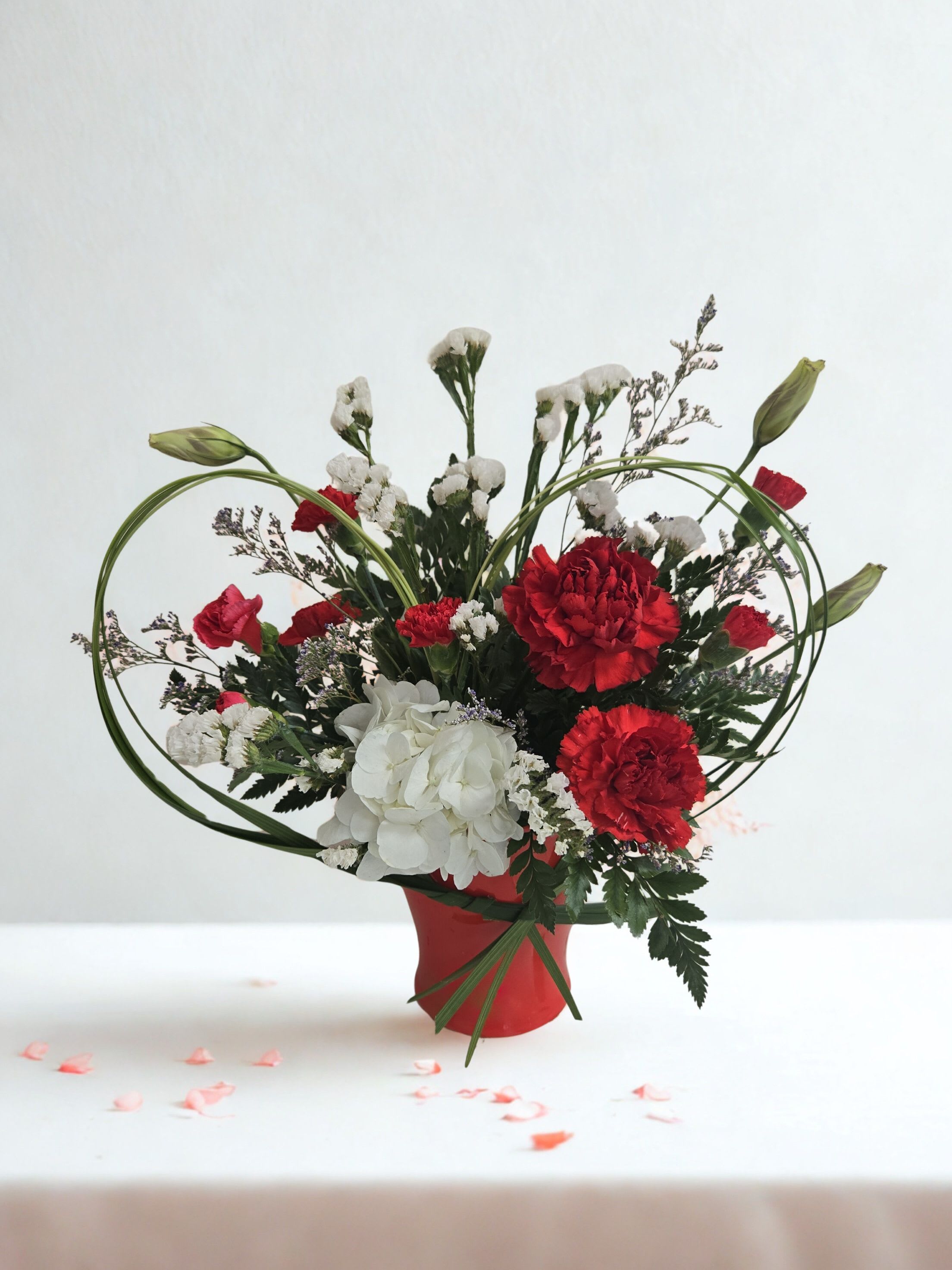 Timeless Affection - Elegant and thoughtfully composed, Timeless Affection blends vibrant red hues with soft white details and fresh seasonal greenery. Designed with balance and movement in mind, this arrangement offers a classic, polished look that feels both warm and modern—ideal for meaningful moments and heartfelt gestures.