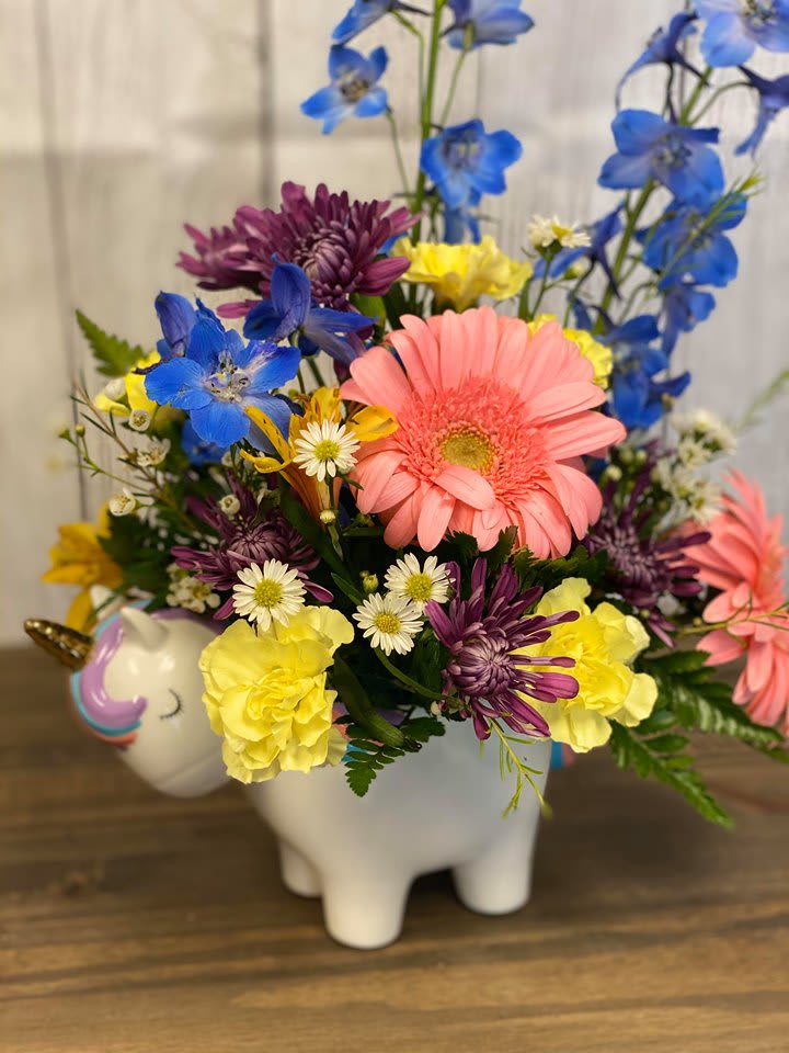 CFB106 - A colorful mixture of Purple, Blue &amp; Pink flowers arranged in a keepsake Ceramic Unicorn container.