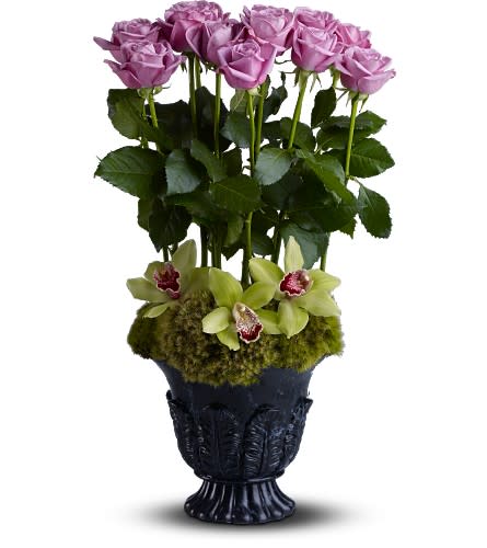 Heavenly Grace - TFWEB539 - With a dozen lavender roses rising from a bed of exotic orchids, this graceful tribute is a touching gesture of remembrance. The decorative urn adds a special touch of elegance.  Three Cymbidium orchids and a dozen roses are nestled in moss and delivered in a Teleflora Timeless Tribute vase.  Approximately 11" (W) x 22" (H)  Orientation: All-Around      As Shown : TFWEB539  