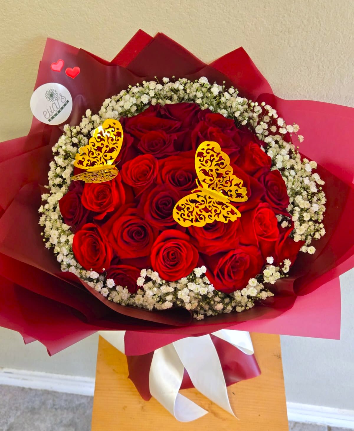 Love is in the Air - Beautiful wrapped bouquet with 24 red roses, golden butterflies, and a cloud of baby's breath.  