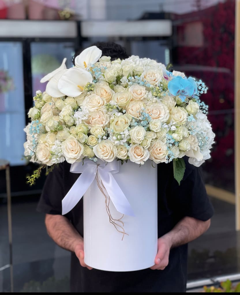 Baby blue bliss - Brighten any space with our Elegant Flower Box Arrangement! Bursting with vibrant blooms, this stunning display combines seasonal favorites with lush fillers.   Housed in a chic, reusable container, it makes a perfect centerpiece for any occasion be it a gift or a treat for yourself. Elevate your decor with this captivating arrangement that brings joy and sophistication to your home or office. Order yours today and let the beauty of flowers inspire you!