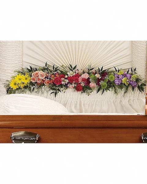 Glorious Memories Garland - Create a beautiful resting place with this magnificent garland of roses and other floral favorites artistically placed at the base of the casket lid.  The exquisite arrangement includes hot pink spray roses, peach spray roses, light pink alstroemeria, pink miniature carnations, yellow daisy spray chrysanthemums, purple button spray chrysanthemums, green button spray chyrsanthemums, orange snapdragon, lavender stock and purple sinuata statice, accented with assorted greenery.
