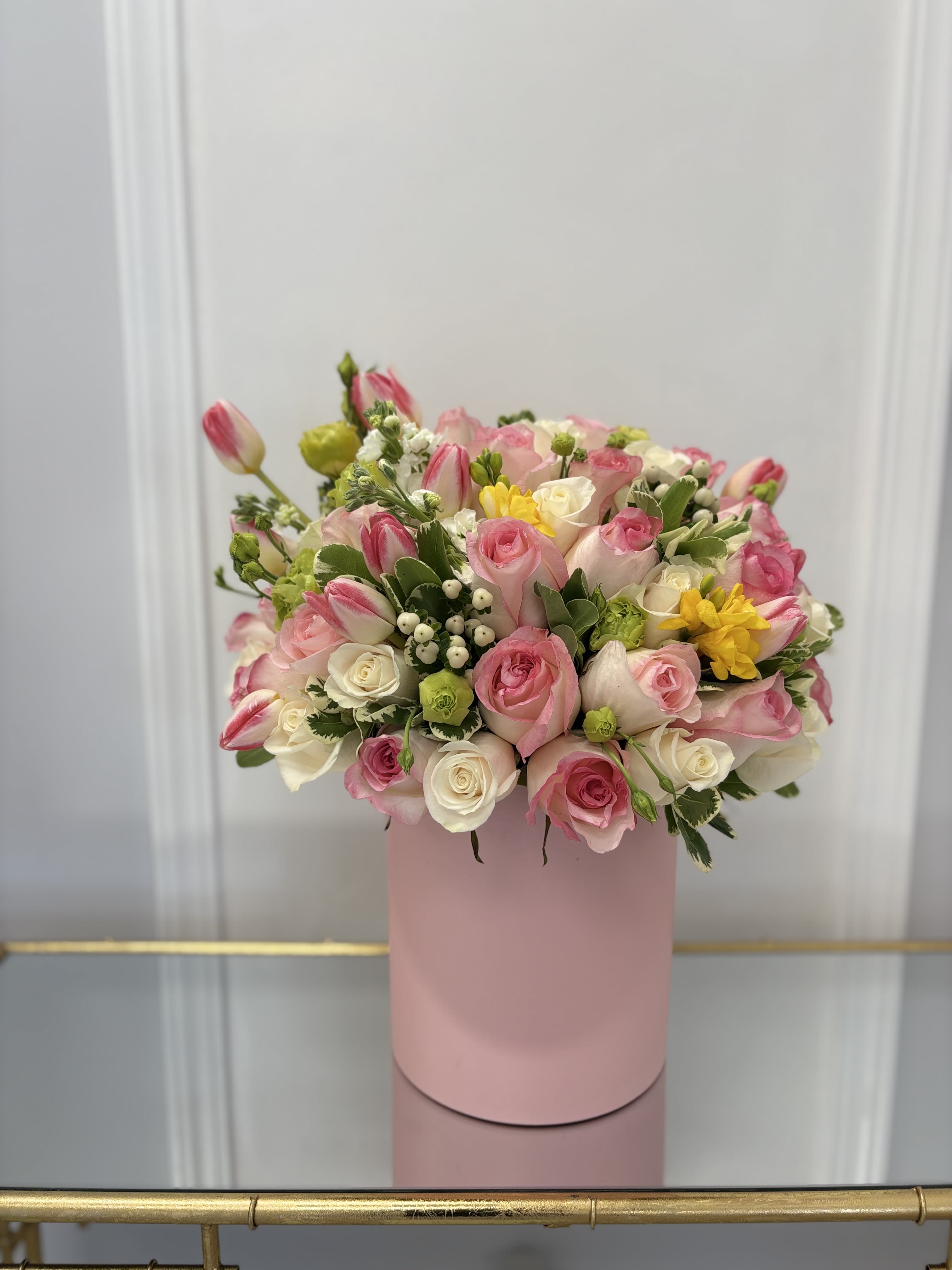 Pink Beauty Hat Box By VLM Flowers - Pink roses and tulips are a delicate combination of yellow, white, and green.