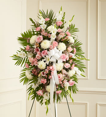 Deepest Sympathies Standing Spray-Pink &amp; White - ]This Sympathy Standing Spray, in shades of peach, orange and white, is a beautiful symbol of your sympathy and support. Pink roses, stargazer lilies, spray roses, white carnations and more An appropriate gift for family, friends and business associates to send directly to the funeral home.