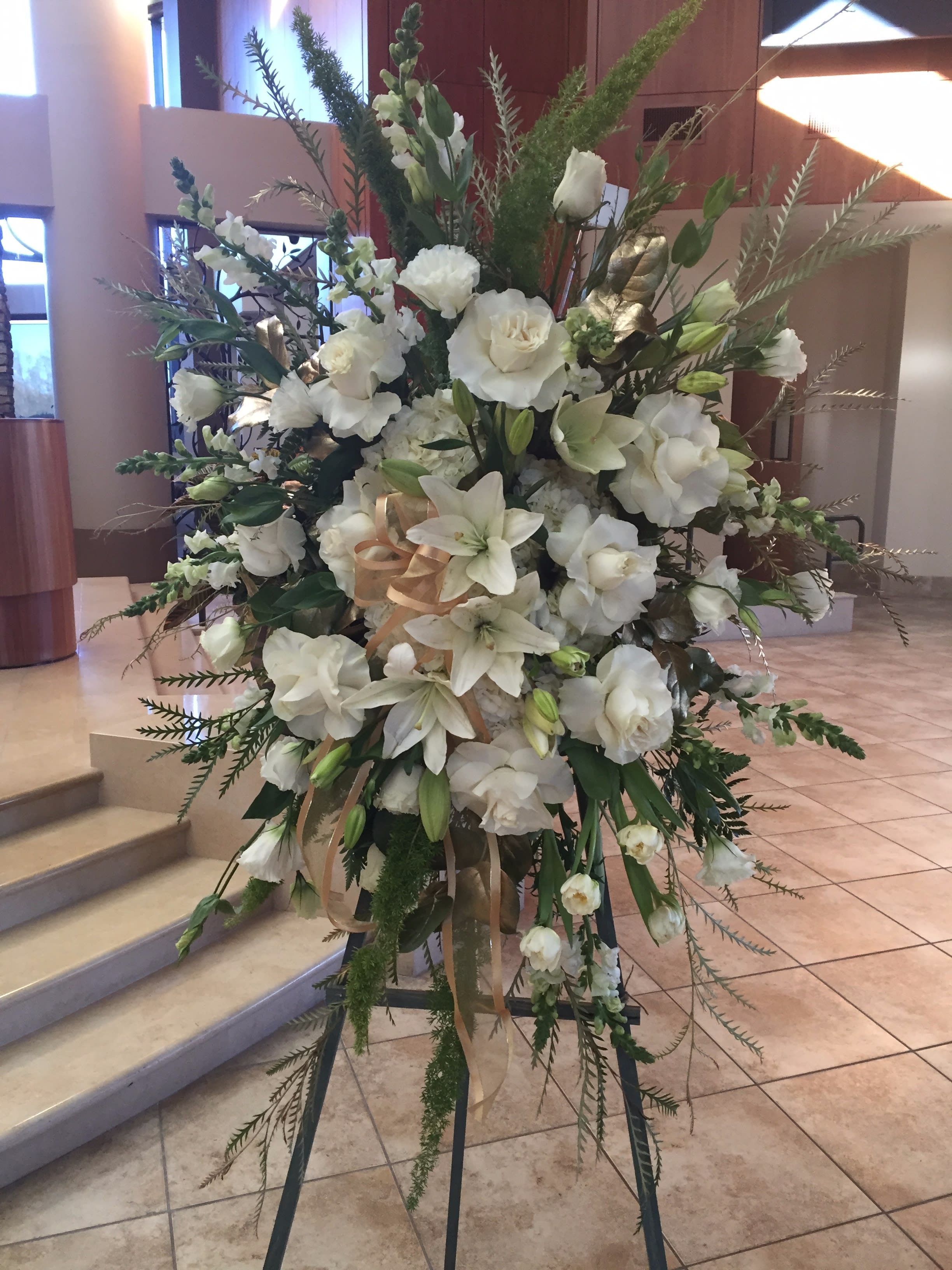 Elegant Premium Sympathy Peace - Must be ordered in advance.  Type of Flowers: Hydrangeas, SnapDragon, Lilies, Roses, Lisianthus, Tulips, Baby Breath, and greens with gold ribbon. Dimensions: Piece on wooden easel 45" long 30" wide Substitute Available in different color ribbons and flowers. Seasonal: All year round  MUST BE ORDERED 1-2 IN ADVANCE