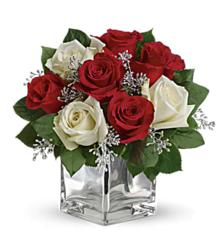 Teleflora's Snowy Night Bouquet - The perfect Christmas hostess gift, this exciting bouquet of red and white roses in a dazzling mirrored cube is guaranteed to make spirits brighter. Simple, stylish, affordable better order one for yourself as well. The delightful holiday bouquet features red roses and white roses accented with assorted greenery. Orientation: All-Around