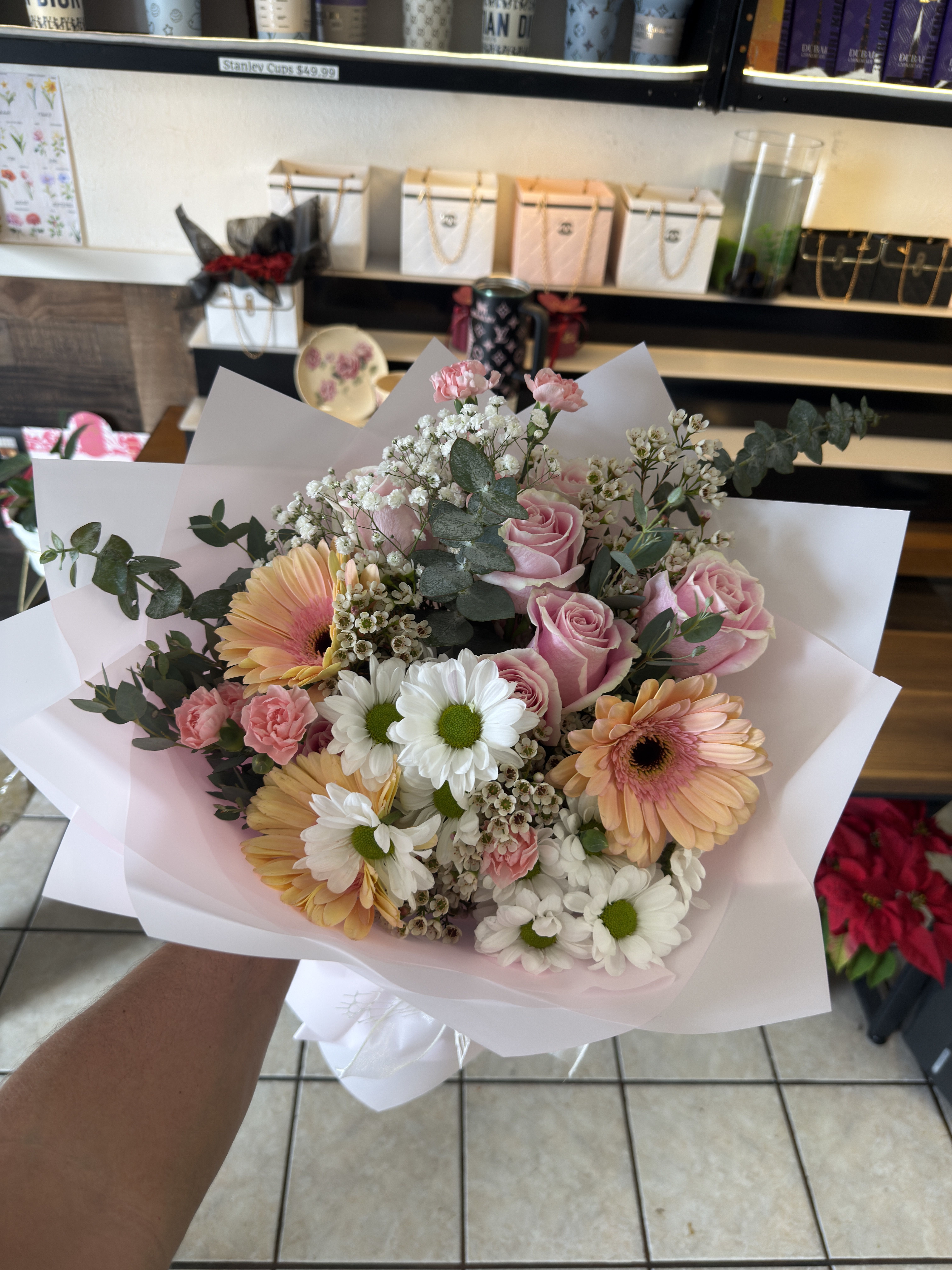 Pastel Poetry Bouquet - Pastel Poetry Bouquet ​Indulge in the soft, dreamlike beauty of our Pastel Poetry arrangement. This hand-tied bouquet features a sophisticated blend of blush pink Roses and velvety Gerbera Daisies in shades of peach and cream. Accented with delicate sprays of Baby’s Breath and fragrant Eucalyptus, this arrangement is finished with crisp white and pink daisies to create a look of timeless elegance. ​Best for: Anniversaries, birthdays, or a "just because" romantic gesture.