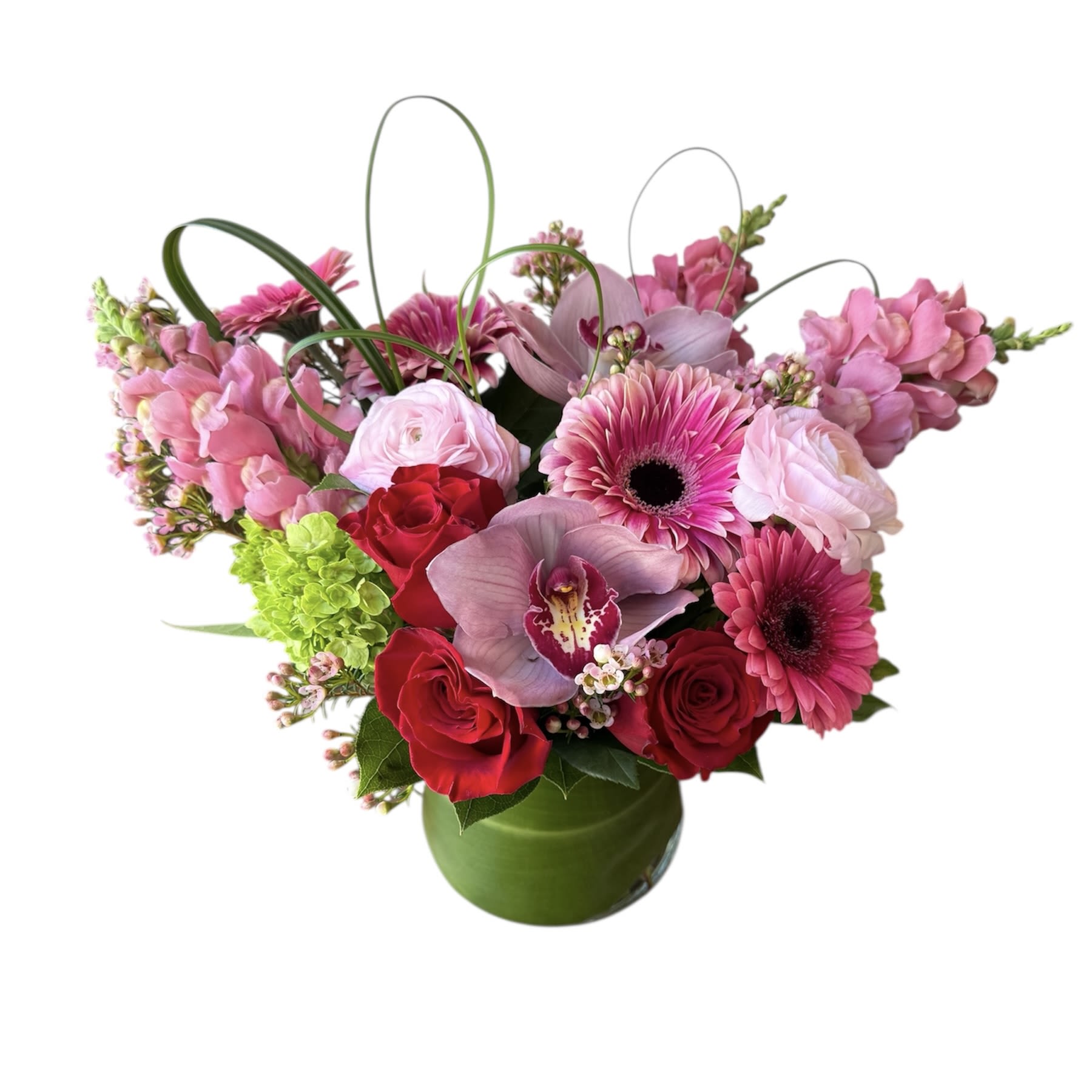 Love Collection - Roses, gerbera daisy, ranunculus, green hydrangea, pink cymbidium orchids, pink snapdragons, wax flowers and heart shaped leafs designed in a glass vase. As shown in photo.