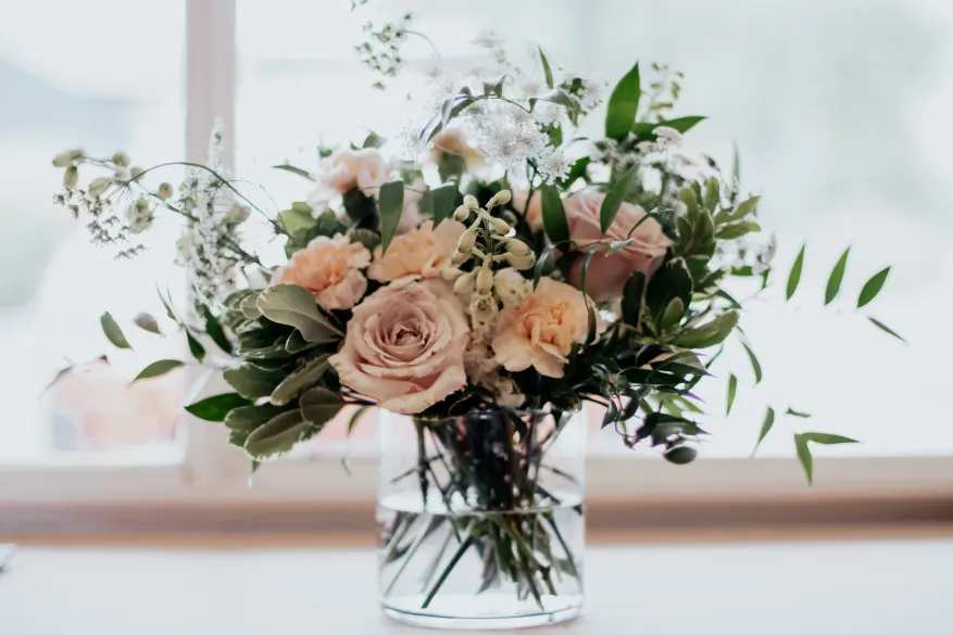 Blushing Beauty - This Mother's Day, surprise Mom with the Blushing Beauty bouquet, a delightful burst of blooms designed to express your love and gratitude. Soft pink and blush roses, white delphinium and light peach carnations are artfully arranged, creating a timeless and elegant tribute to the special woman in your life. The Blushing Beauty is a guaranteed way to bring a smile to Mom's face and brighten her day.