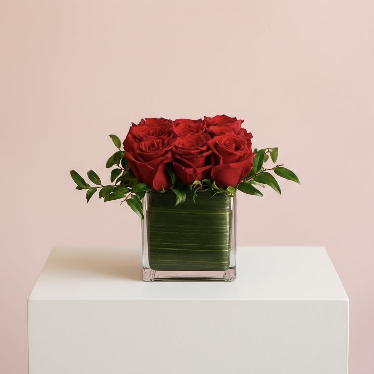 Red Rose Cube - This romantic arrangement showcases nine premium red roses, artfully styled with lush greenery in a leaf-lined 5" glass cube for a timeless, elegant presentation.  Handcrafted by our floral designers in Brentwood, this arrangement is available for flower delivery throughout West Los Angeles (including Brentwood, Santa Monica, Beverly Hills, Bel Air, Westwood, Pacific Palisades, Culver City, and surrounding Los Angeles neighborhoods)