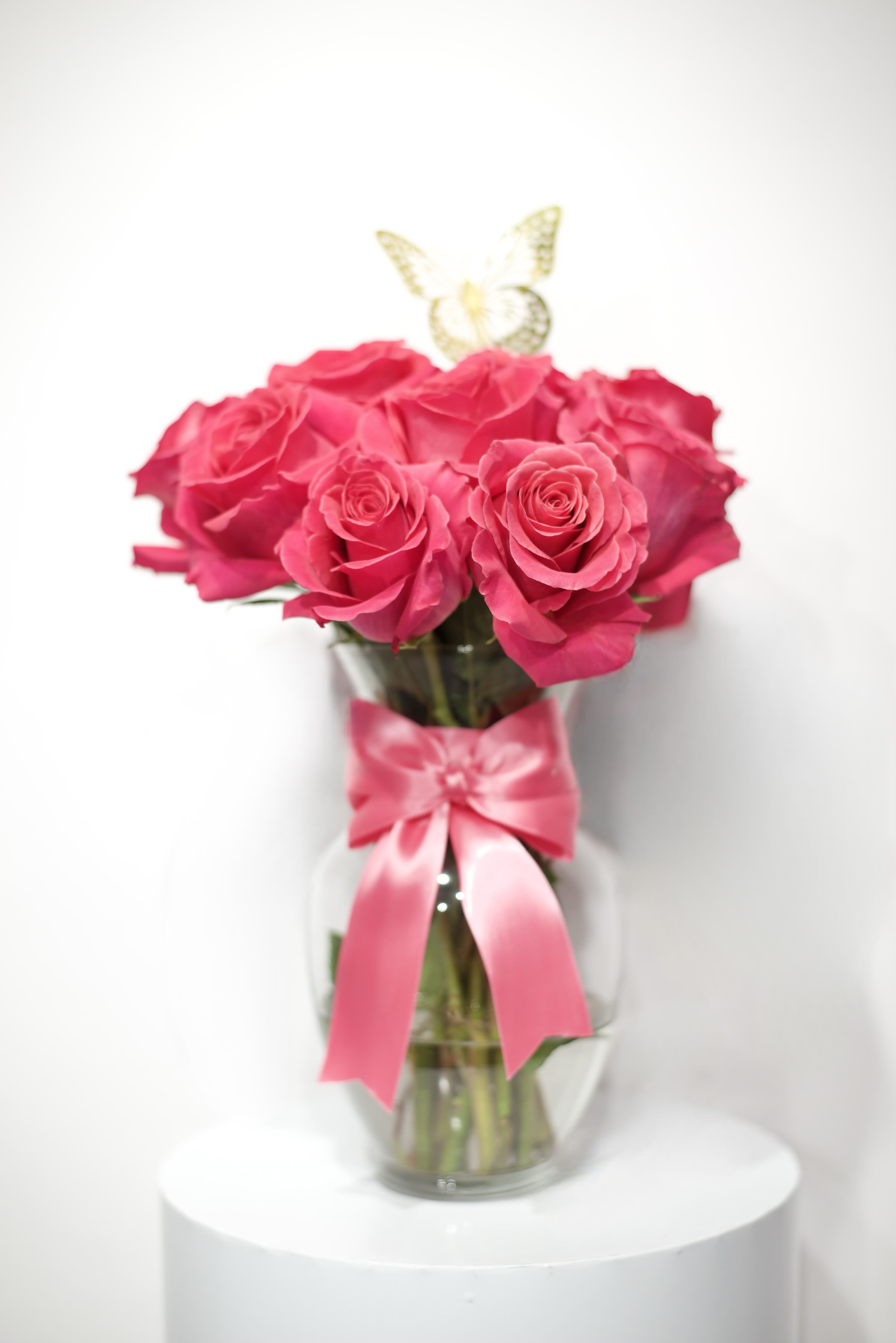 Hot pink short stem roses - Our pink arrangement has been create to elevate your occasion 1,2,3 dozen natural roses decorate with ribbons butterflies in a clear base.