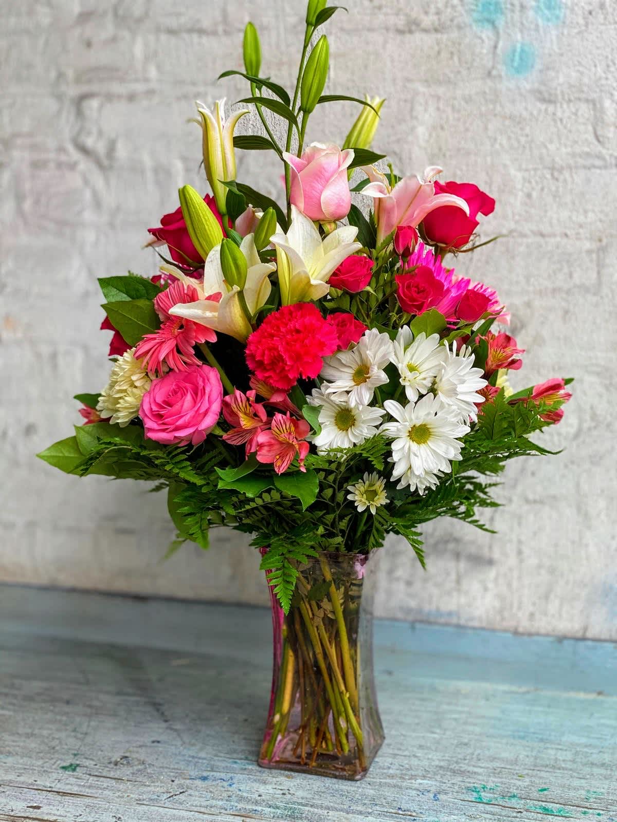 House mix - vibrant mix of lilies, daisies, roses, sunflowers, and greenery. ideal for center pieces. events, or as a thoughtful gift. Brighten up any space with this beautiful floral arrangement 
