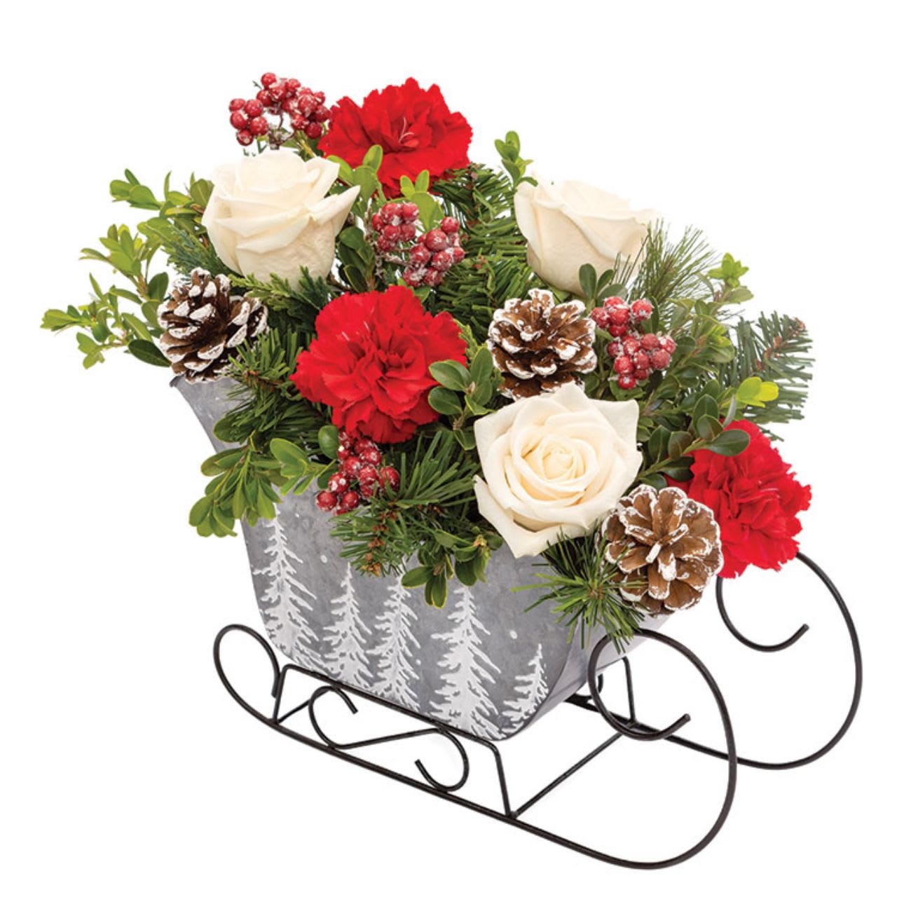 Winter’s Eve Sleigh - Details: Roses, Carnations, &amp; Assorted Christmas Greens Dimensions: Arrangement Height 14", Length 11"