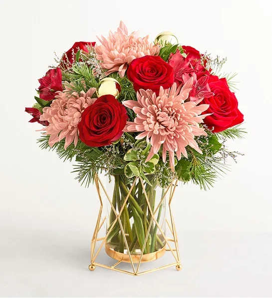 Christmas Pop of Color - The very definition of merry and bright, this bouquet brings both classic beauty and contemporary grace to a holiday home. Roses, Peruvian lilies, and other blooms are accented with Christmas greenery and arranged in a gleaming metal-and-glass vase. Arrangement of red roses and Peruvian lilies (alstroemerias), pink mum disbuds, and purple limonium, accented with assorted Christmas greenery.