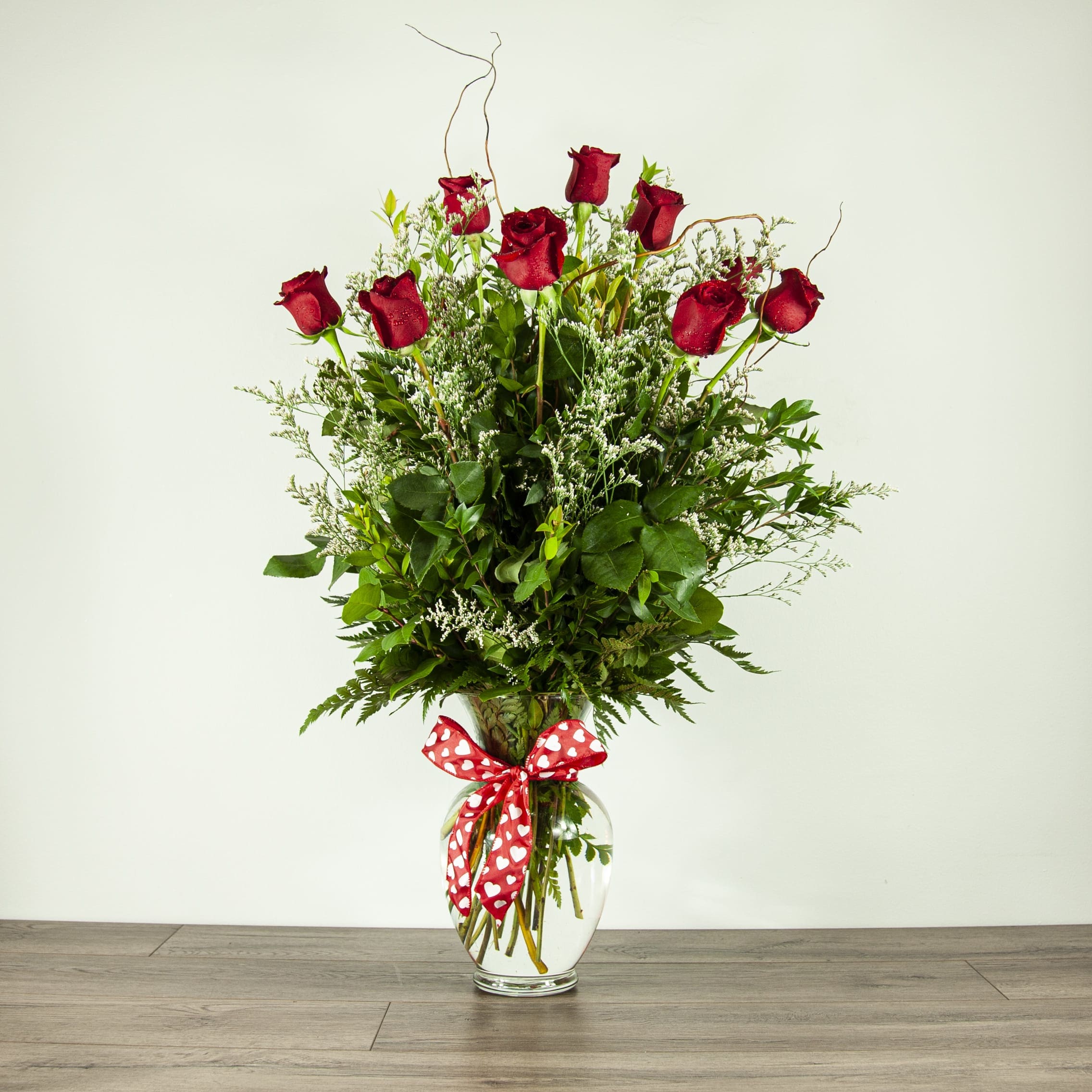 Deluxe Dozen Red Roses (EXP 42) - A fuller, taller version of our classic romantic rose arrangement, finished off with a bow.