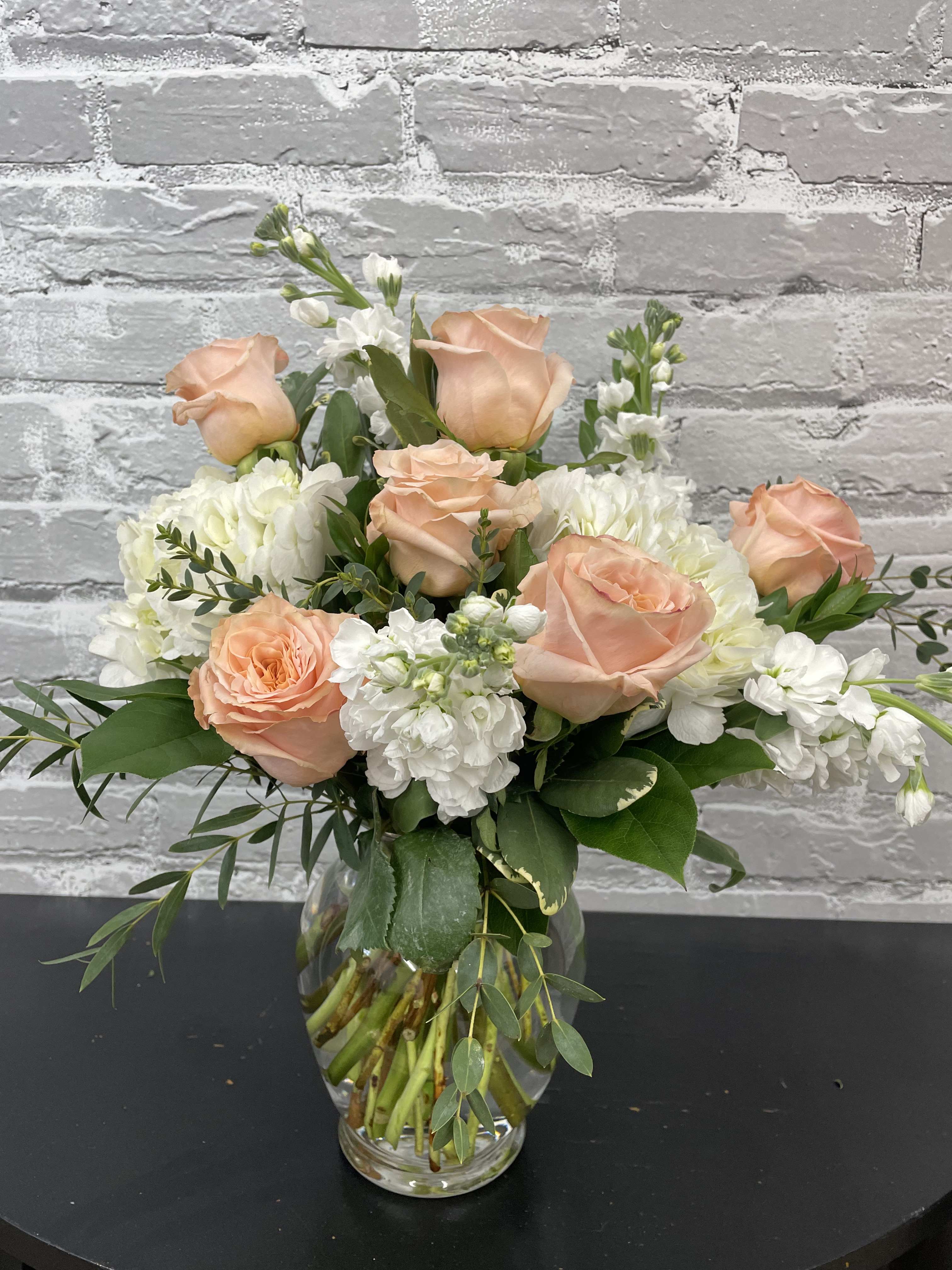 Shimmer - Beautiful peach colored roses, white hydrangeas and white stock. Arranged in a vase with beautiful green foliages added. 
