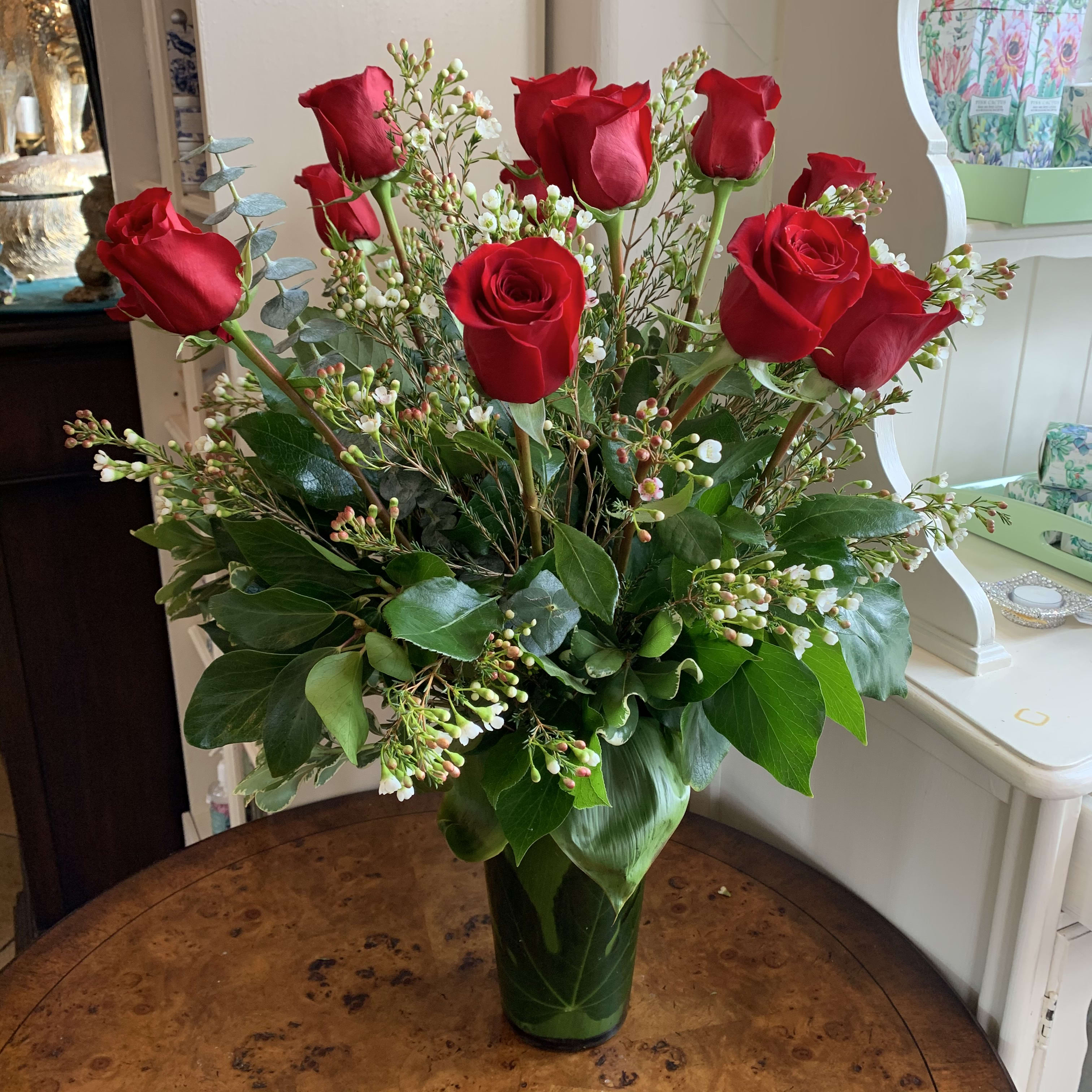 The Red Rose Bouquet - Nothing speaks of love so much as a bouquet of beautiful long stem red roses. Arranged with premium green and complimenting filler flower in a  classic glass vase, leaf lined to hide the stems. This bouquet is a gift to her heart from yours. Standard Version is a dozen. Deluxe is 18 roses and premium is 2 dozen roses