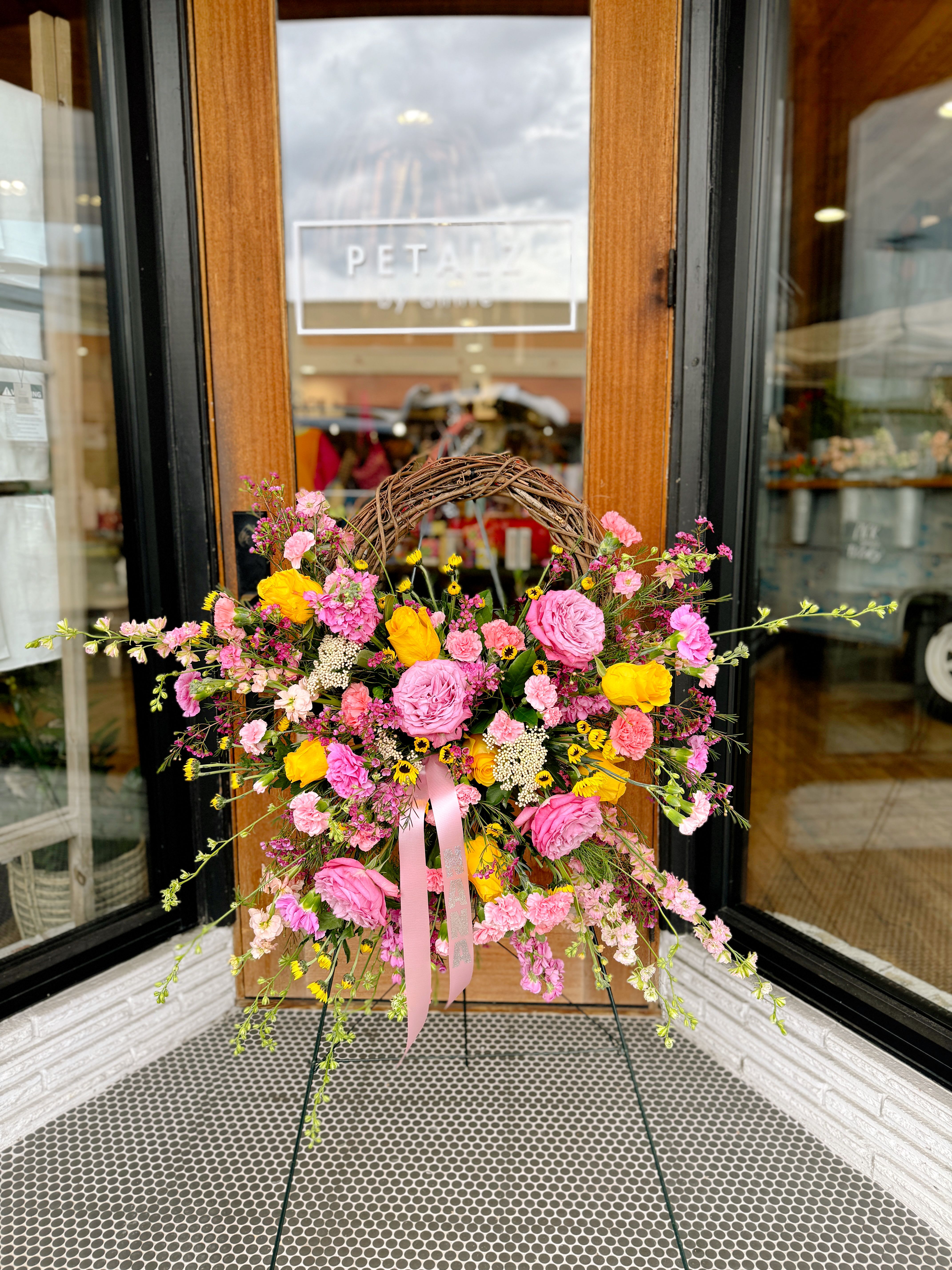 Bundle of Pink  - This wicker wreath standing spray is uniquely designed with fresh florals. Exact florals may very depending on product availability. 