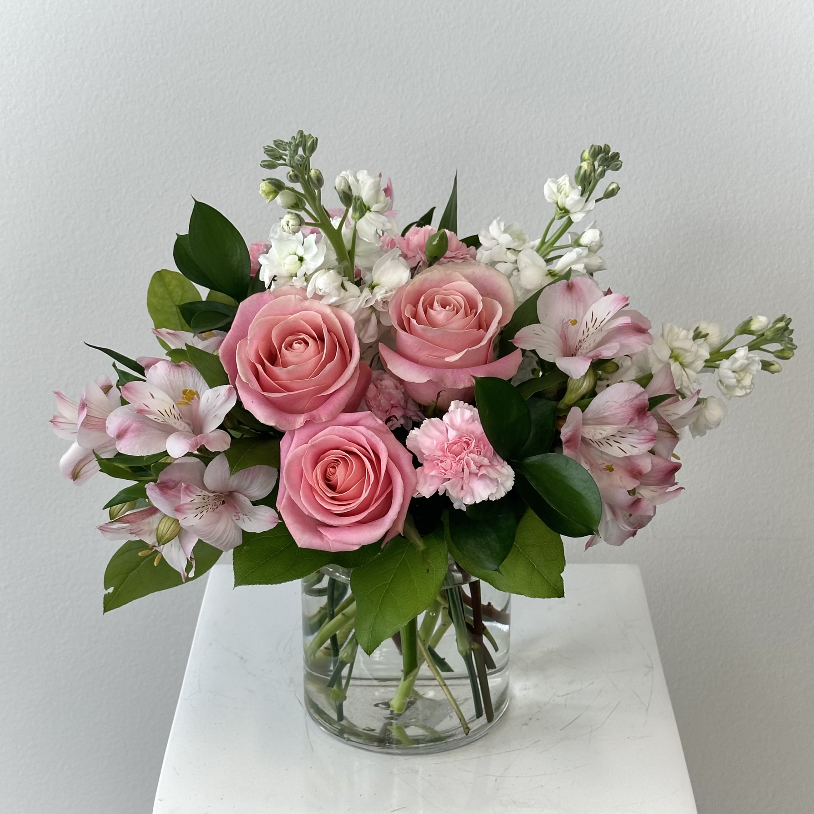 At The Ballet - Gather ‘round, dear friends, because Irvine Village Flowers is pirouetting into a tale of pure floral delight! Imagine lacing up your pointe shoes for the *At the Ballet Bouquet*, a graceful masterpiece twirling with blushing pink flowers and classic white stems. It’s a natural beauty that’s perfect for classic souls who adore a touch of elegance and a whole lot of charm.  Picture this: a bouquet that dances to its own sweet rhythm—soft pink blooms swaying alongside crisp white stems, creating a harmony that’s as lovely as a ballet under the spotlight. At Irvine Village Flowers, we’ve crafted this Deluxe Bouquet to stand about 15 inches high and 15 inches wide, a perfect stage for showing your soulmate, your bestie, or even yourself some heartfelt love. Pink whispers gratitude and affection, while white sings of purity and grace—together, they’re a standing ovation in flower form!  Let’s take a bow for these blooms! The blushing pink flowers bring a romantic flush, full of charm and new beginnings, while the classic white stems add a timeless elegance that lasts and lasts. It’s a natural pairing that’s both stunning and meaningful, designed to lift spirits and warm hearts with every glance.  Twirl on over to Irvine Village Flowers—online or in-store—and let us bring this ballet of blooms to life. With our joyful Irvine flower delivery, it’ll arrive fresh, fabulous, and ready to spread beauty and cheer wherever it lands!