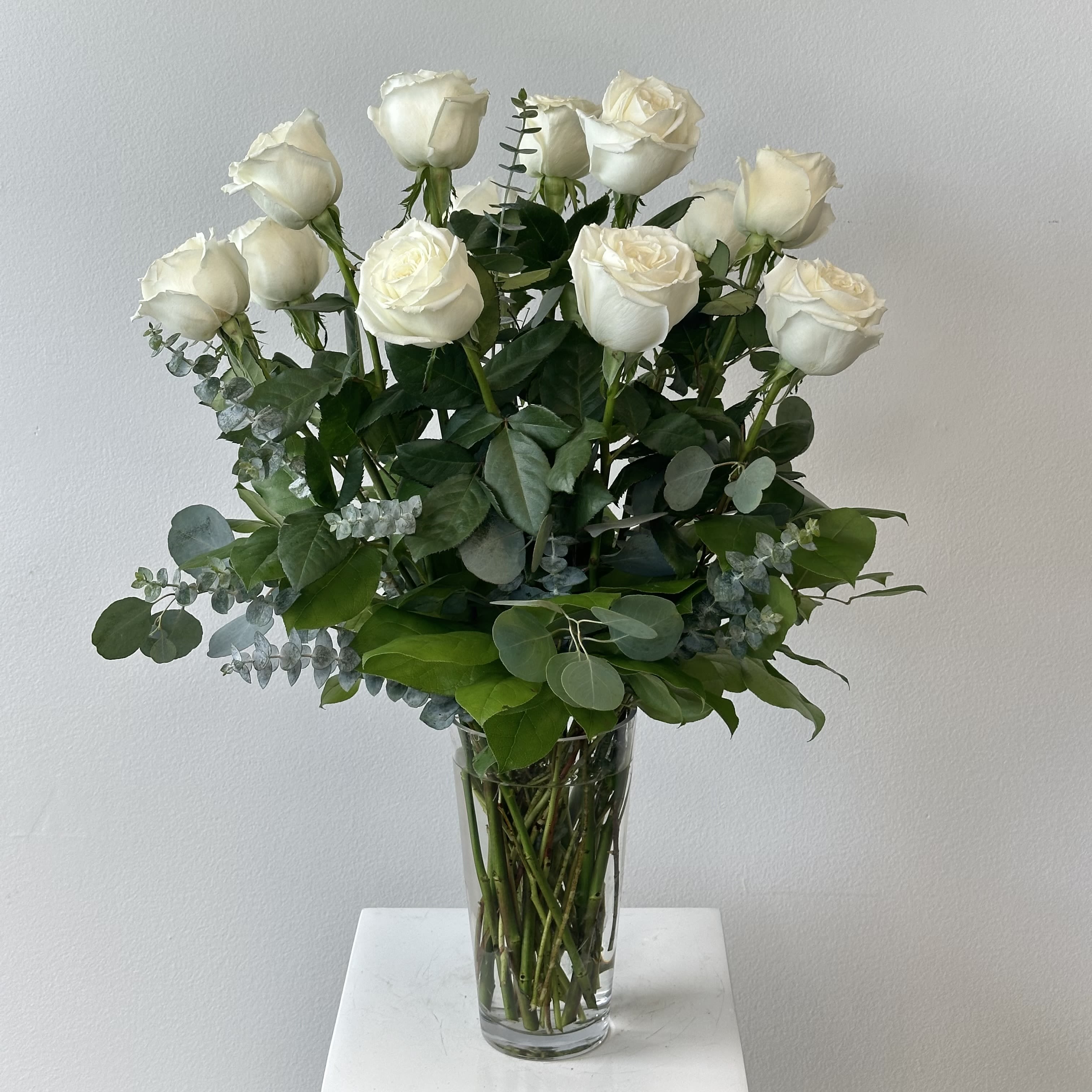 Dozen White Roses - This arrangement is a bouquet of one dozen premium white roses with greenery. 
