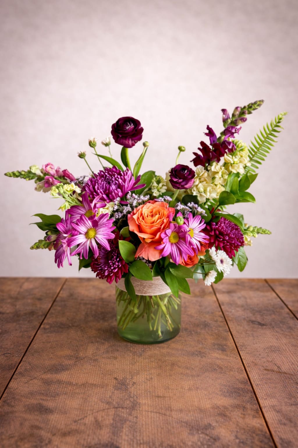 Lumi's Petal Perfection  - The combination of purple and orange flowers creates a harmonious and balanced look that will enhance the overall aesthetic of your home. Add a touch of nature and color to your living space with this stunning vase filled with purple and orange flowers.  A unique arrangement hand created by our experienced designers. Please note that every design is custom made and substitution to container and flower types may happen from time to time. Design aspects will always stay the same, but if needed, we will substitute with flowers of equal or greater value to offer you a great floral shopping experience! Our flowers are 100% guaranteed. Please call us with any questions or concerns.