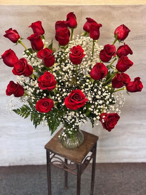 24 red Roses - A classic arrangement of vibrant red roses accented with delicate baby’s breath and fresh greenery, elegantly displayed in a clear glass vase—perfect for expressing love, admiration, or celebrating any special occasion. 