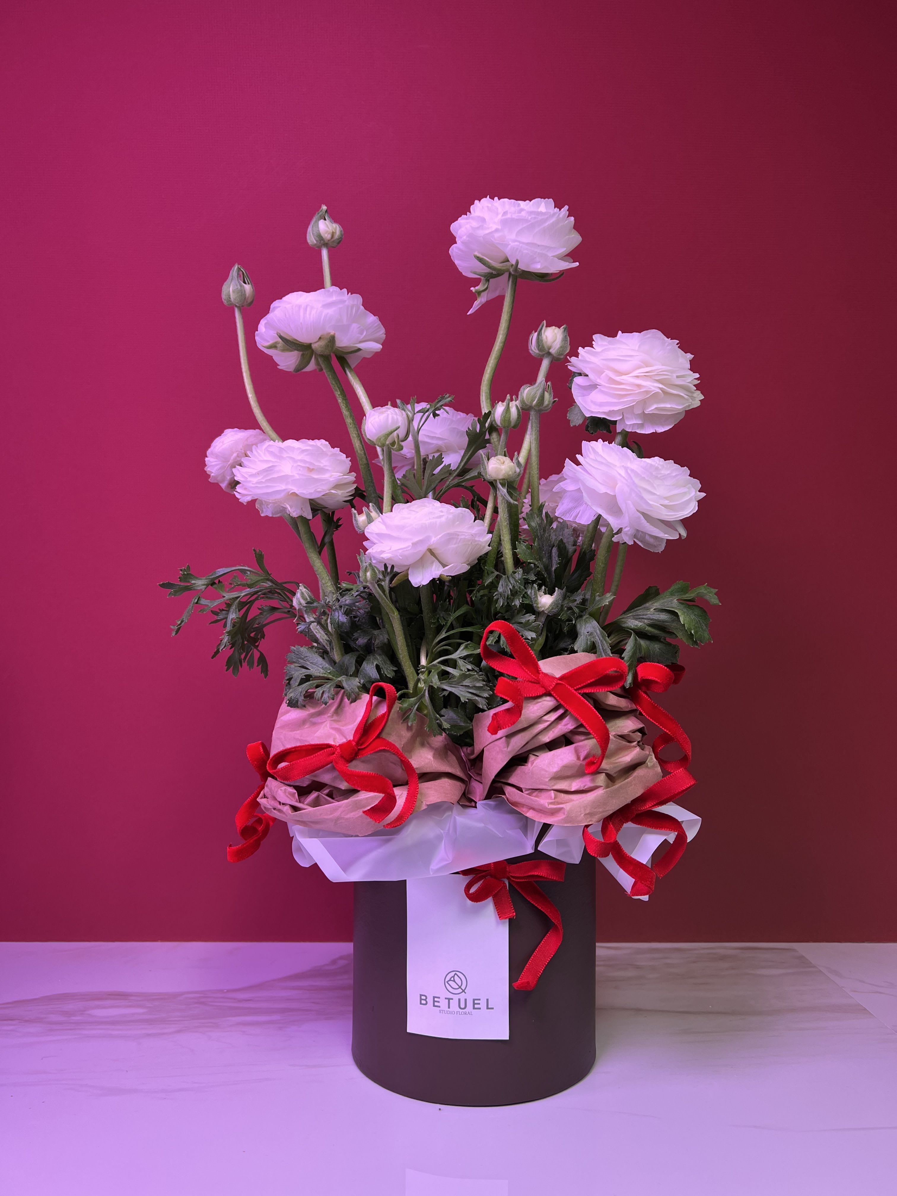 TRUE LOVE/ REAL LOVE - The arrangement was created by BETUEL STUDIO FLORAL, a company  that specializes in contemporary floral art, blending design and style. The flowers come in a chocolate round box with brown paper accents and red velvet ribbons.