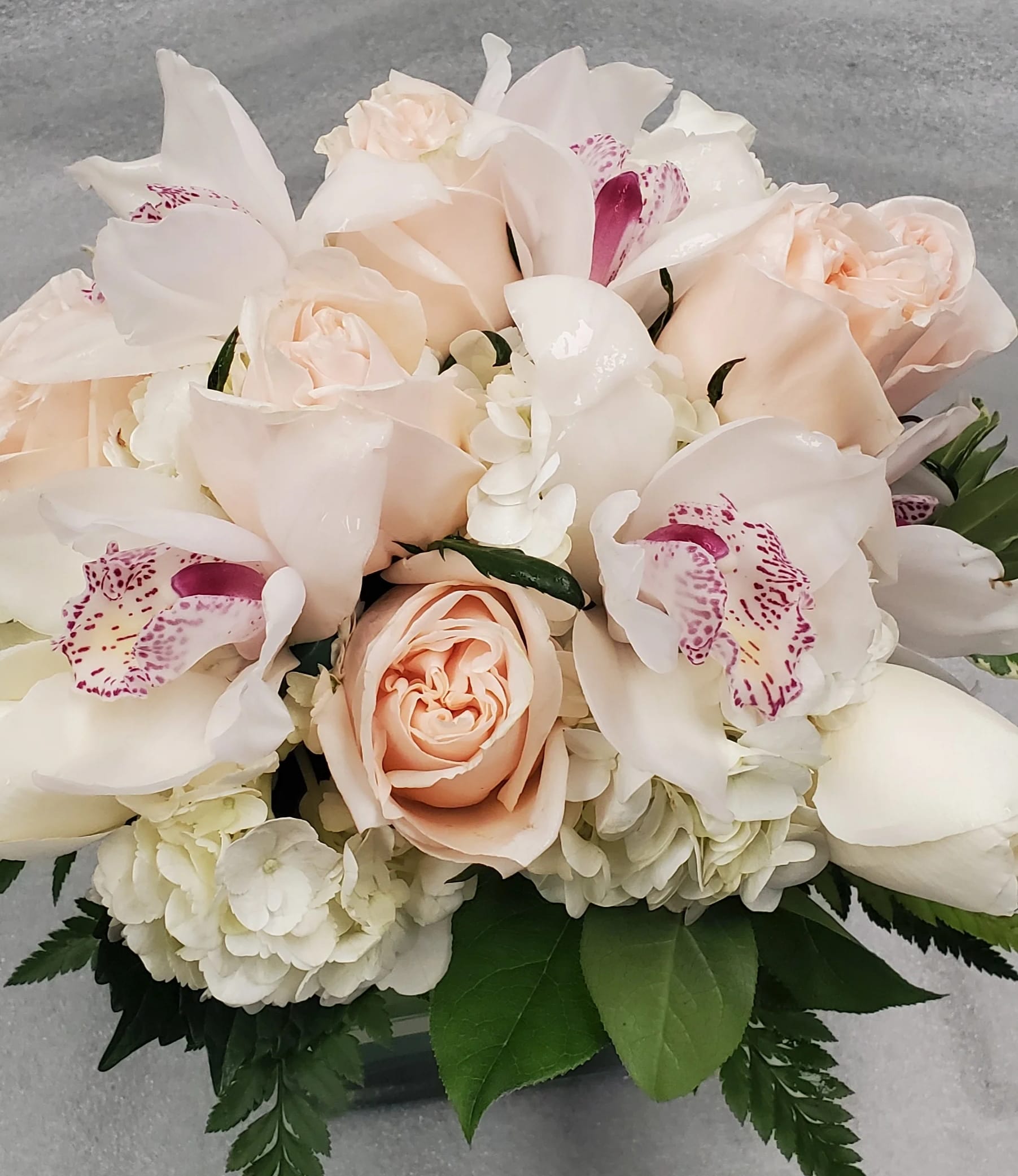 Elegant  - This bouquet shows that there is beauty in simplicity. Elegant, is the perfect gift for almost any occasion, especially for celebrations and showing gratitude.  Features hydrangea, roses and orchids.   Arrangement Details: Includes white roses, blush pink roses, white cymbidium orchids, and white hydrangea. APPROXIMATE DIMENSIONS:10" H X 11" W X 11"L