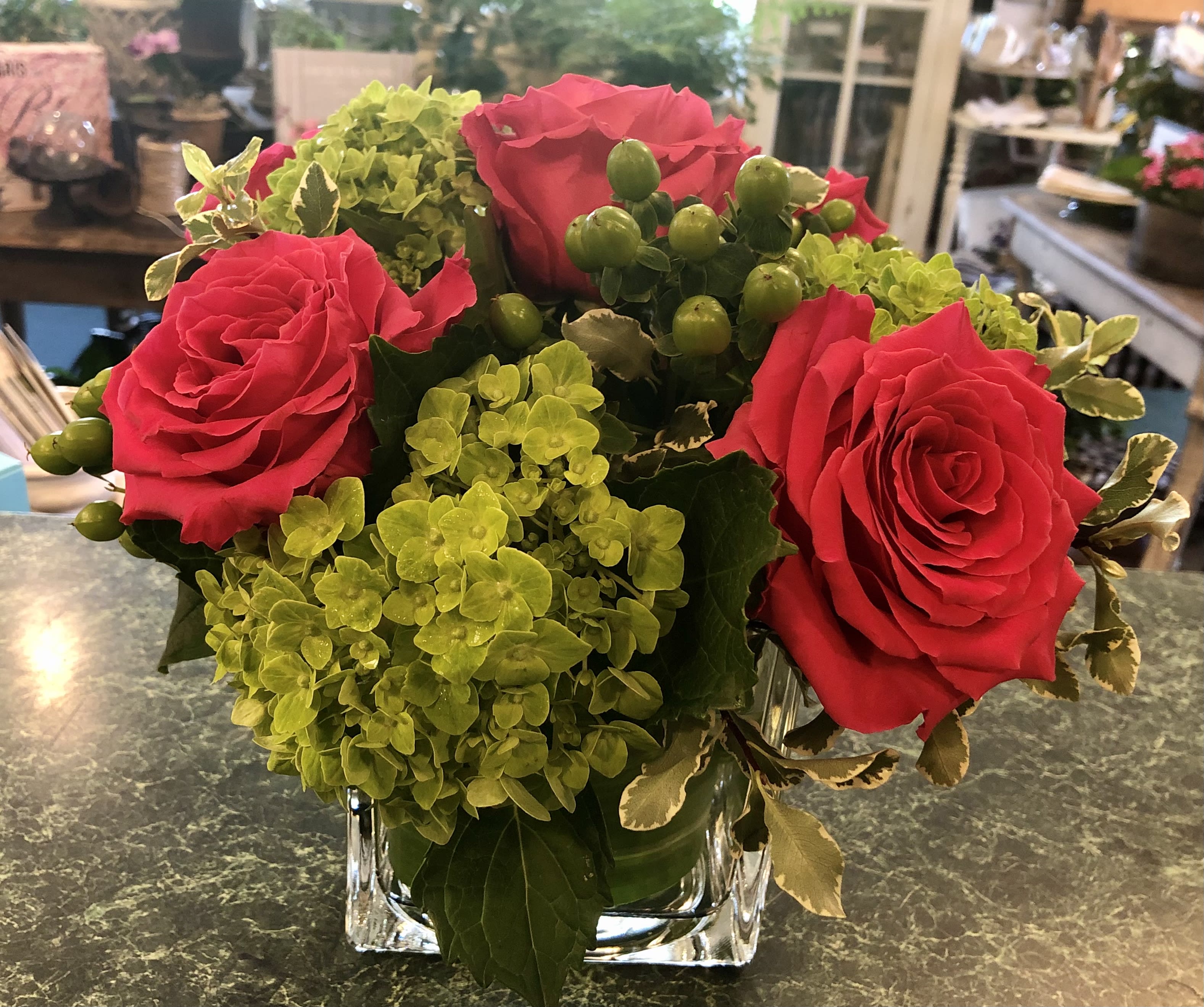 Full Monte Roses &amp; Hydrangeas - Stunning mix of Hot Pink Full Monte roses arranged with green hydrangeas and green hypericum berries in 5” sq cube.